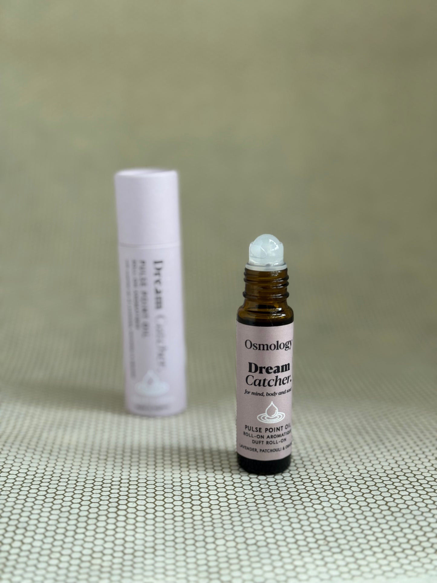 Osmology Dream Catcher pulse point roll-on aromatherapy oil with baby pink packaging.