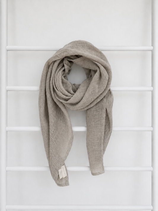 Beige linen scarf draped over a white lattice background