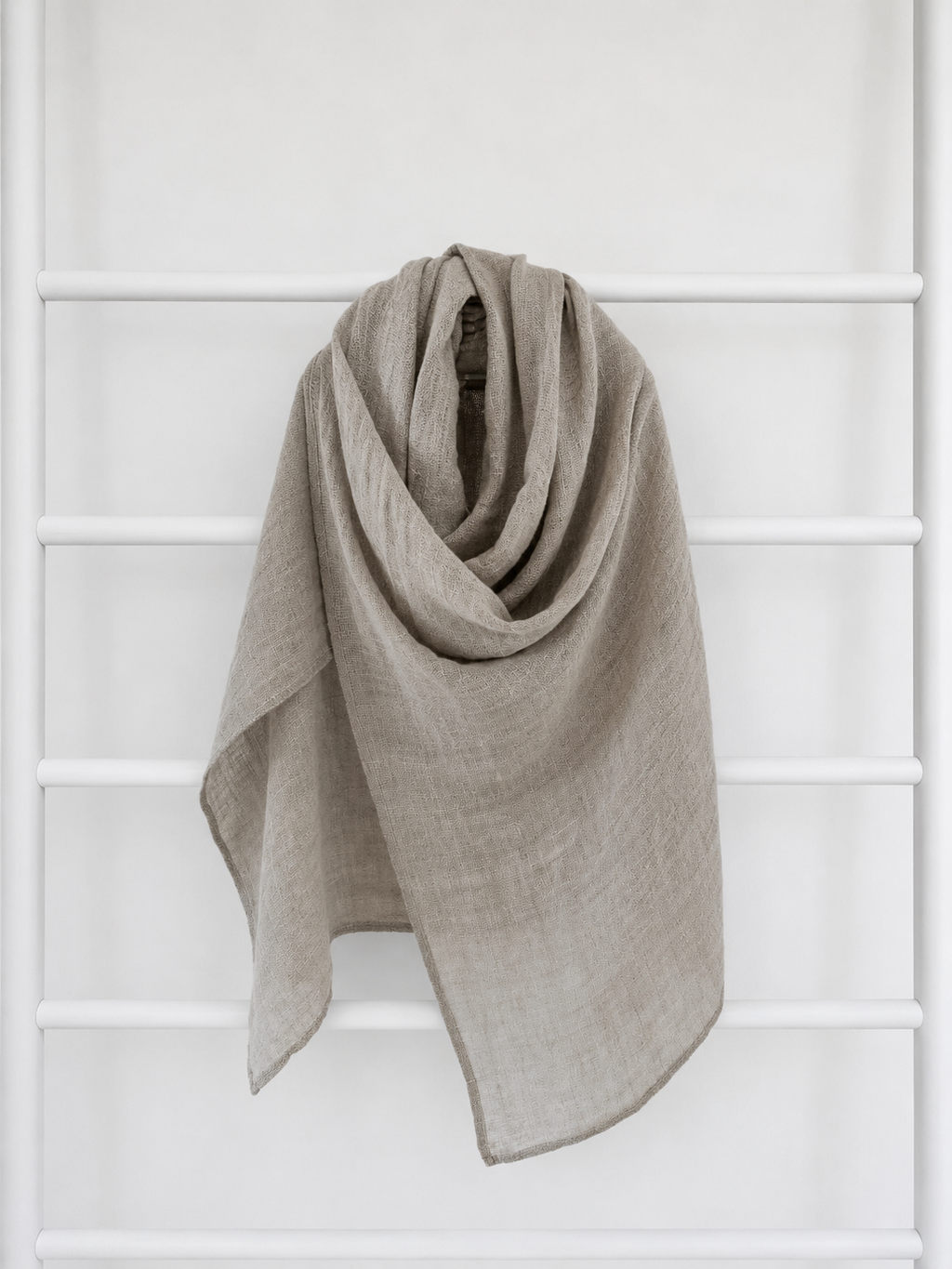 Beige linen scarf draped over a white lattice background