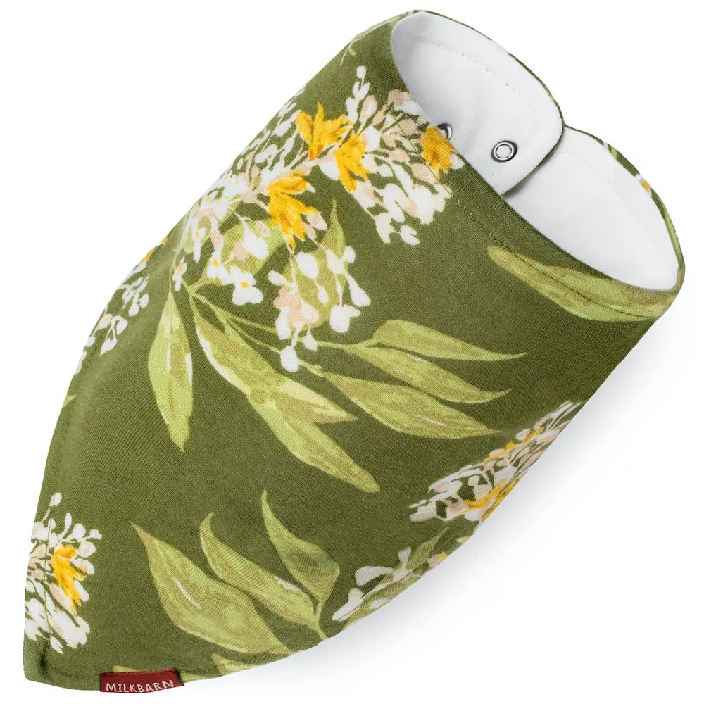 A green and white floral-patterned baby bib with adjustable snap closure by milkbarn.