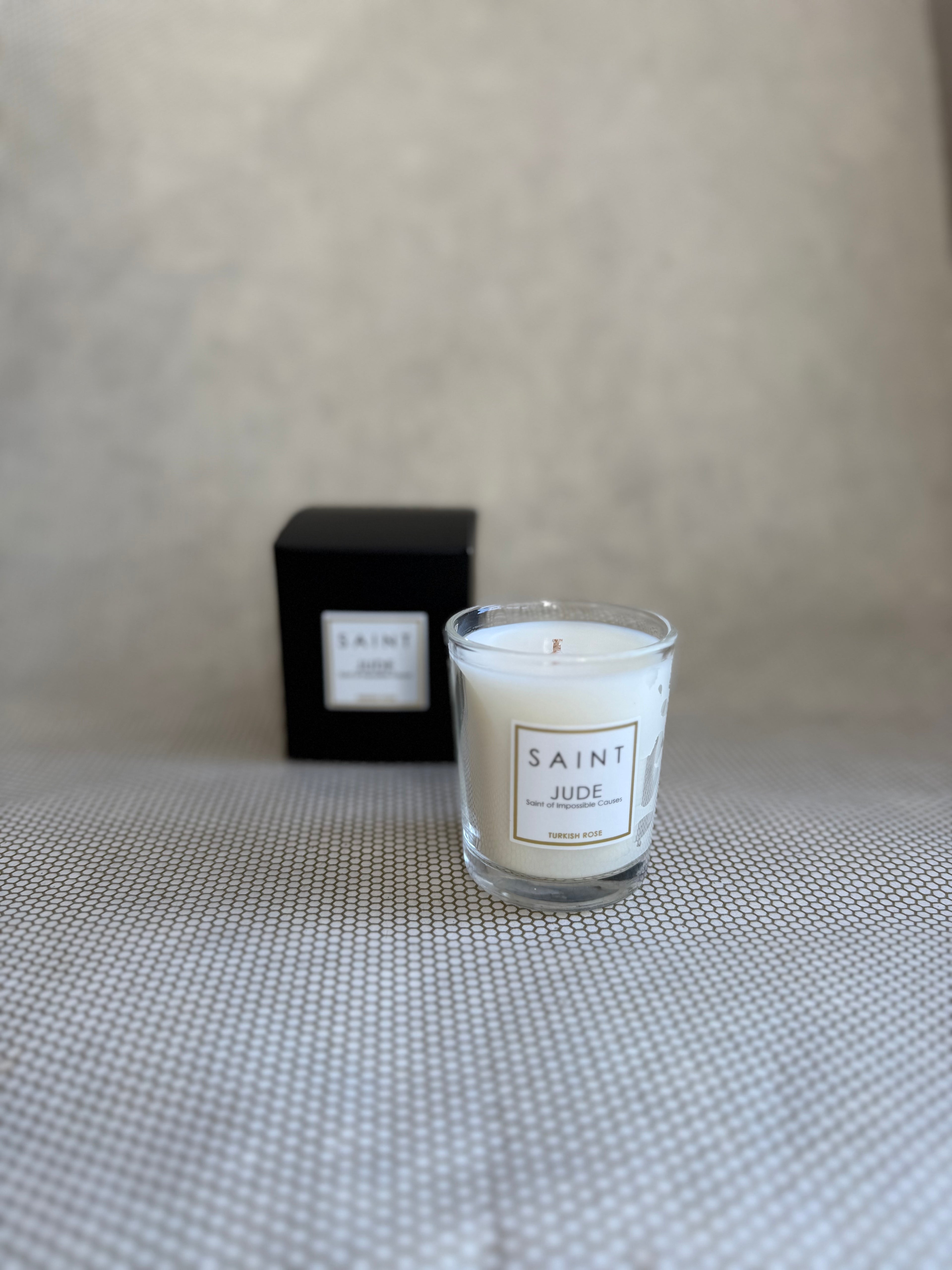 SAINT small votive candle. clear glass white wax in black box. saint jude turkish rose. 3 oz.(2.5 oz. pour). Measures 2.5"Hx2"D.