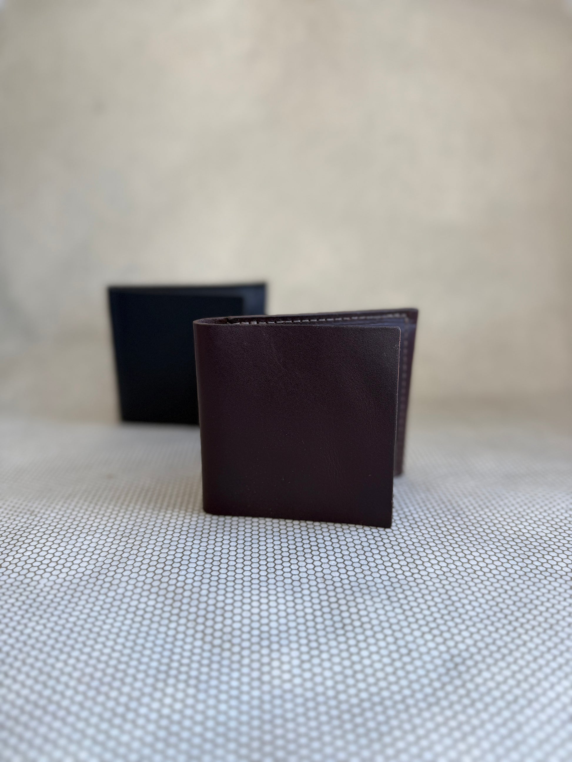 Dean bifold leather wallet made in LA in brown and black on neutral background. 
