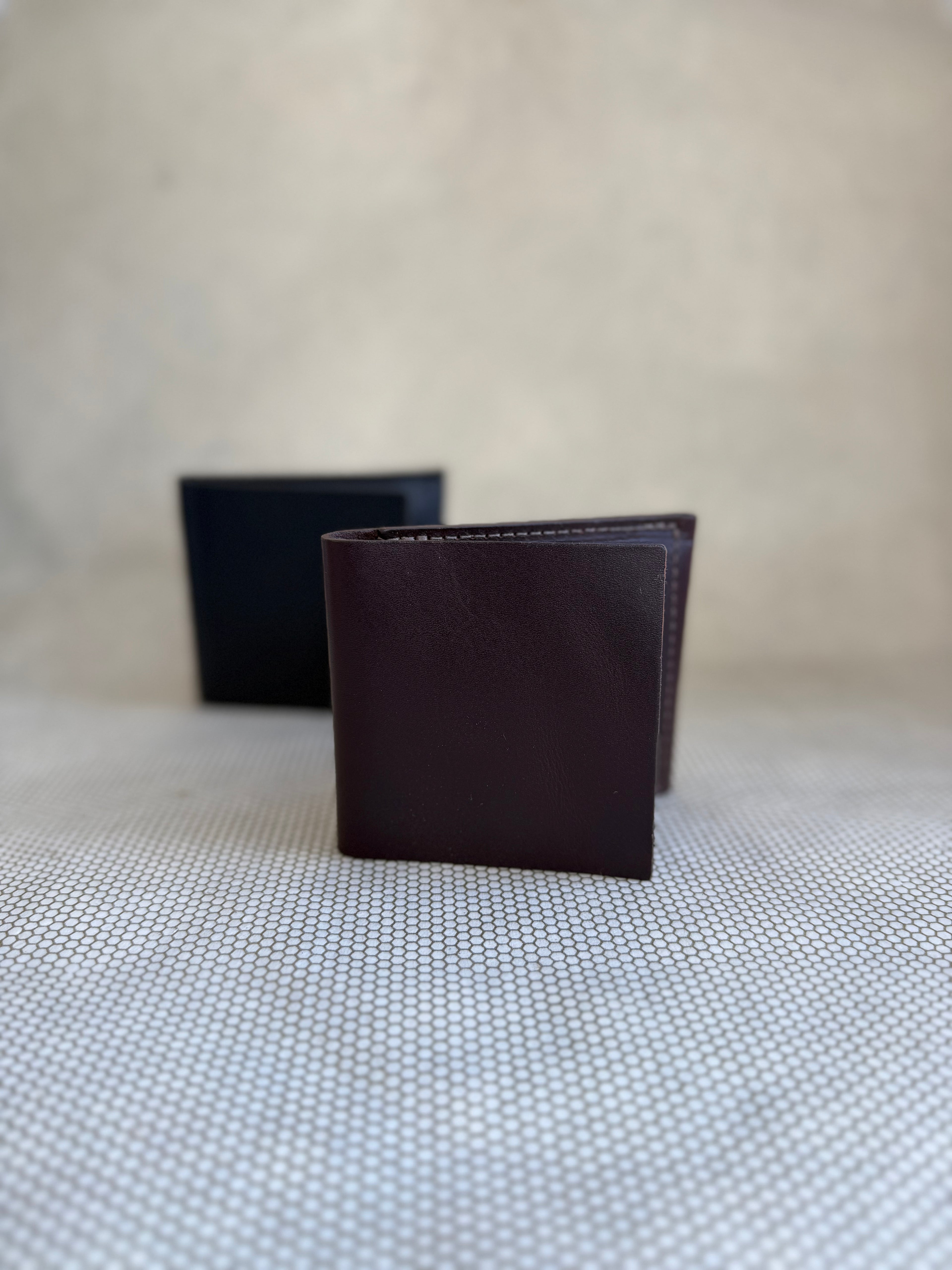 Dean bifold leather wallet made in LA in brown and black on neutral background. 
