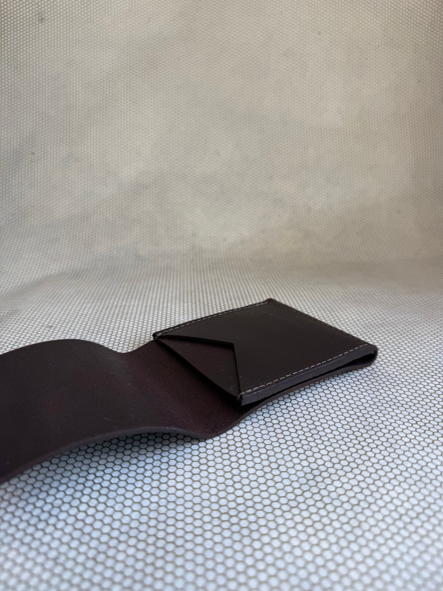 brown leather wallet on a textured beige surface