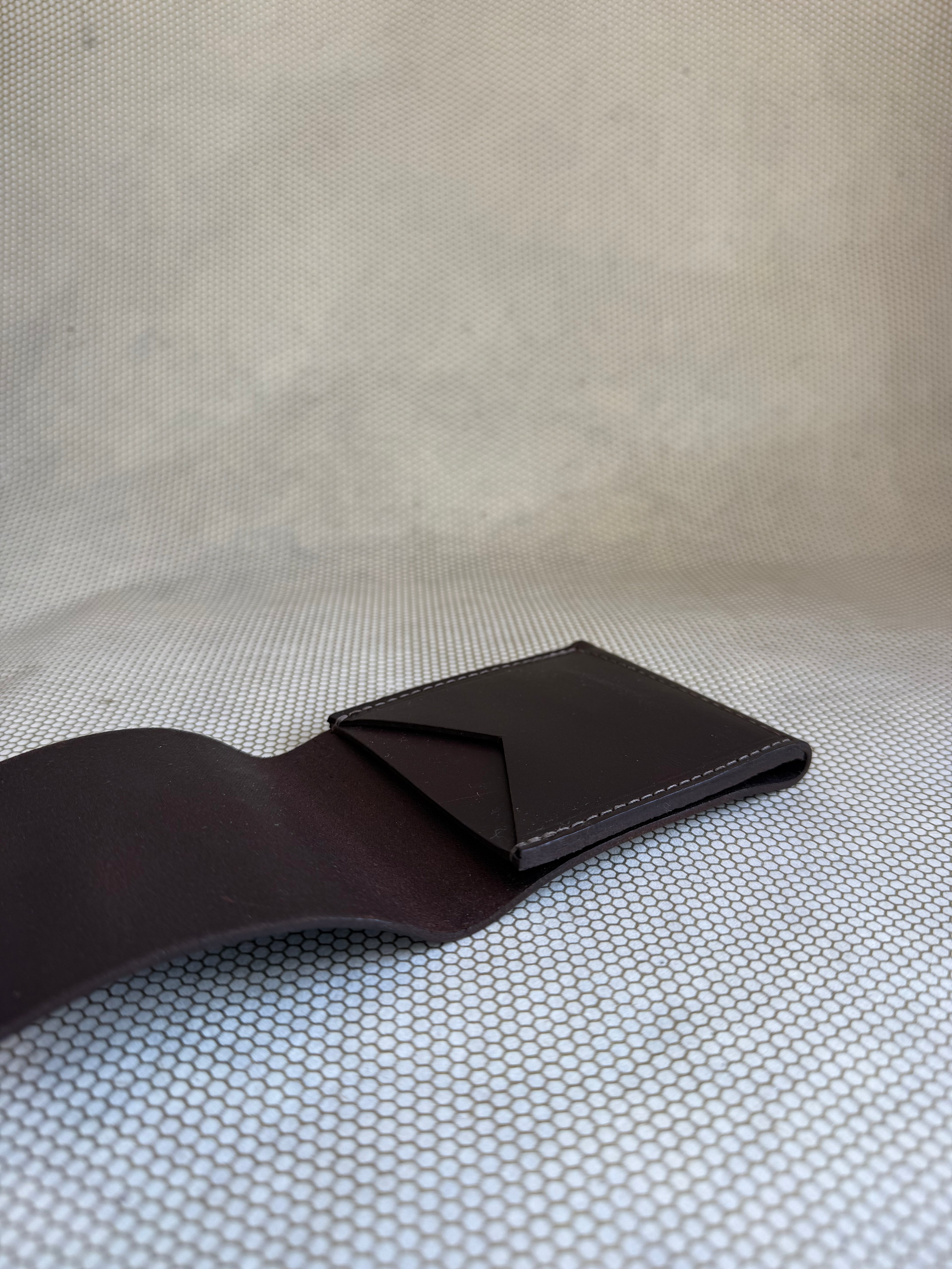 brown leather wallet on a textured beige surface
