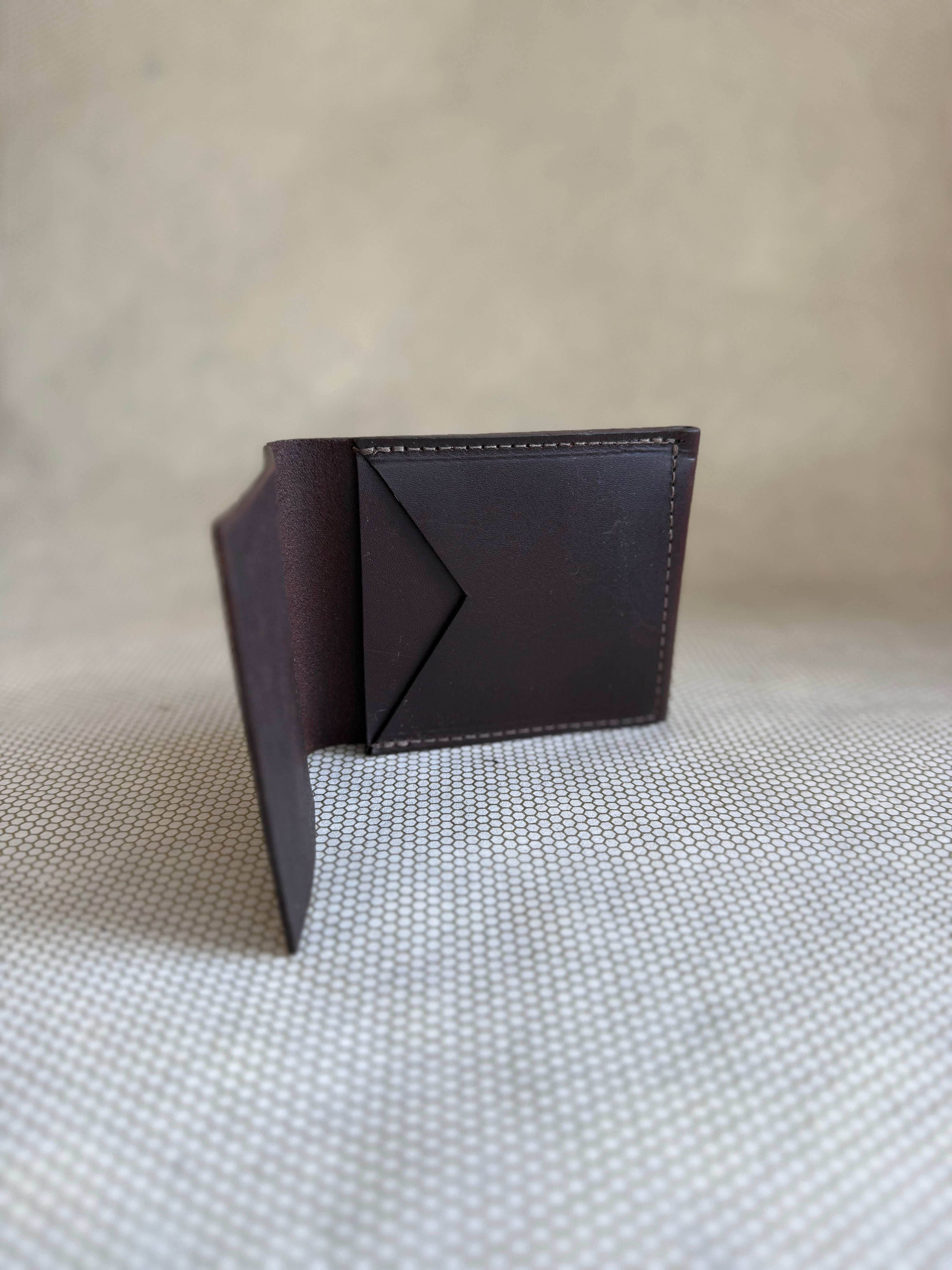 brown leather wallet on a textured beige surface