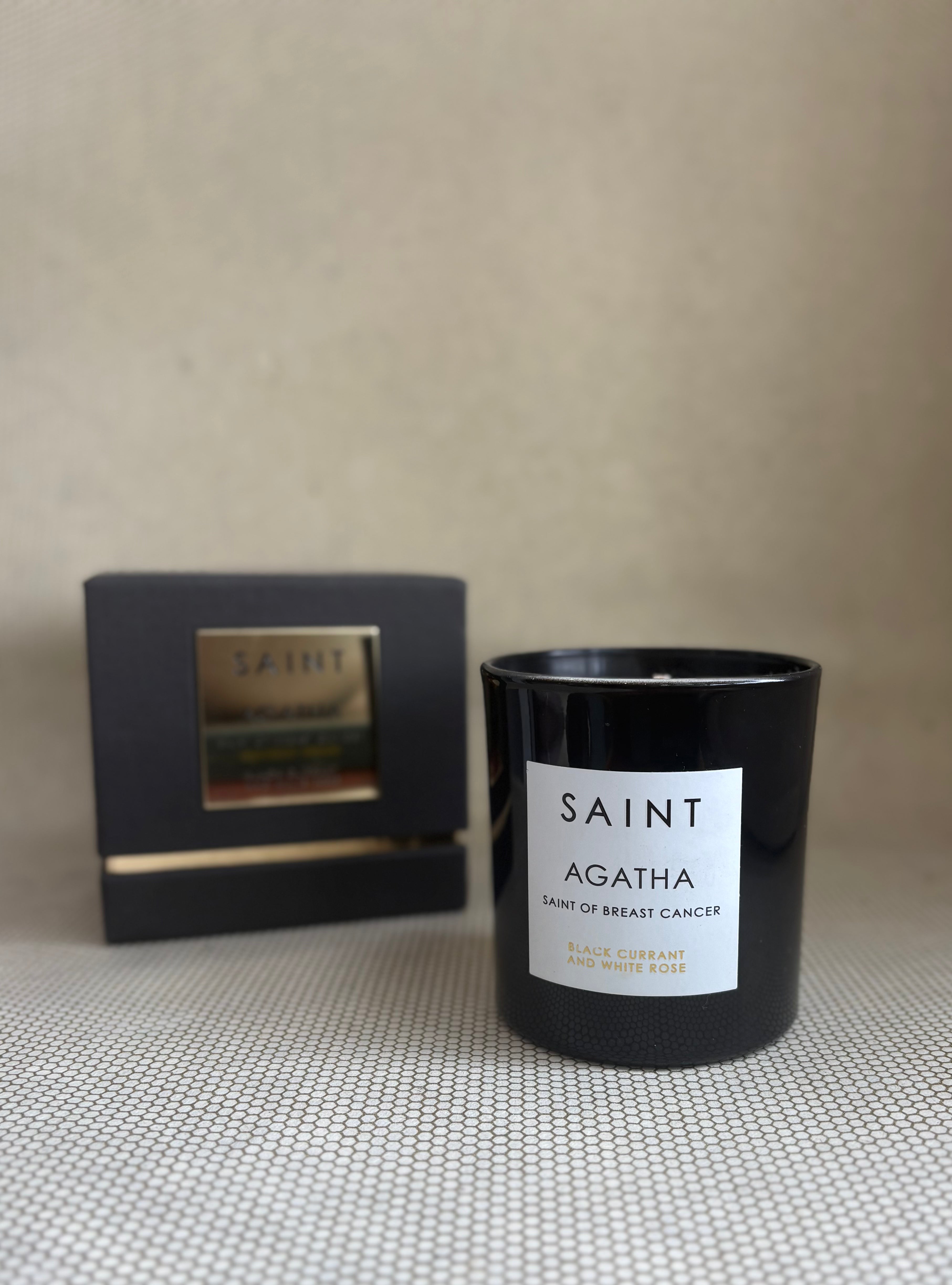 SAINT black glass candle with gold lid. black and gold box for candle. saint agatha black currant and white rose. 11 oz. (8 oz. pour), Measures 3.5" H x 3" D. 