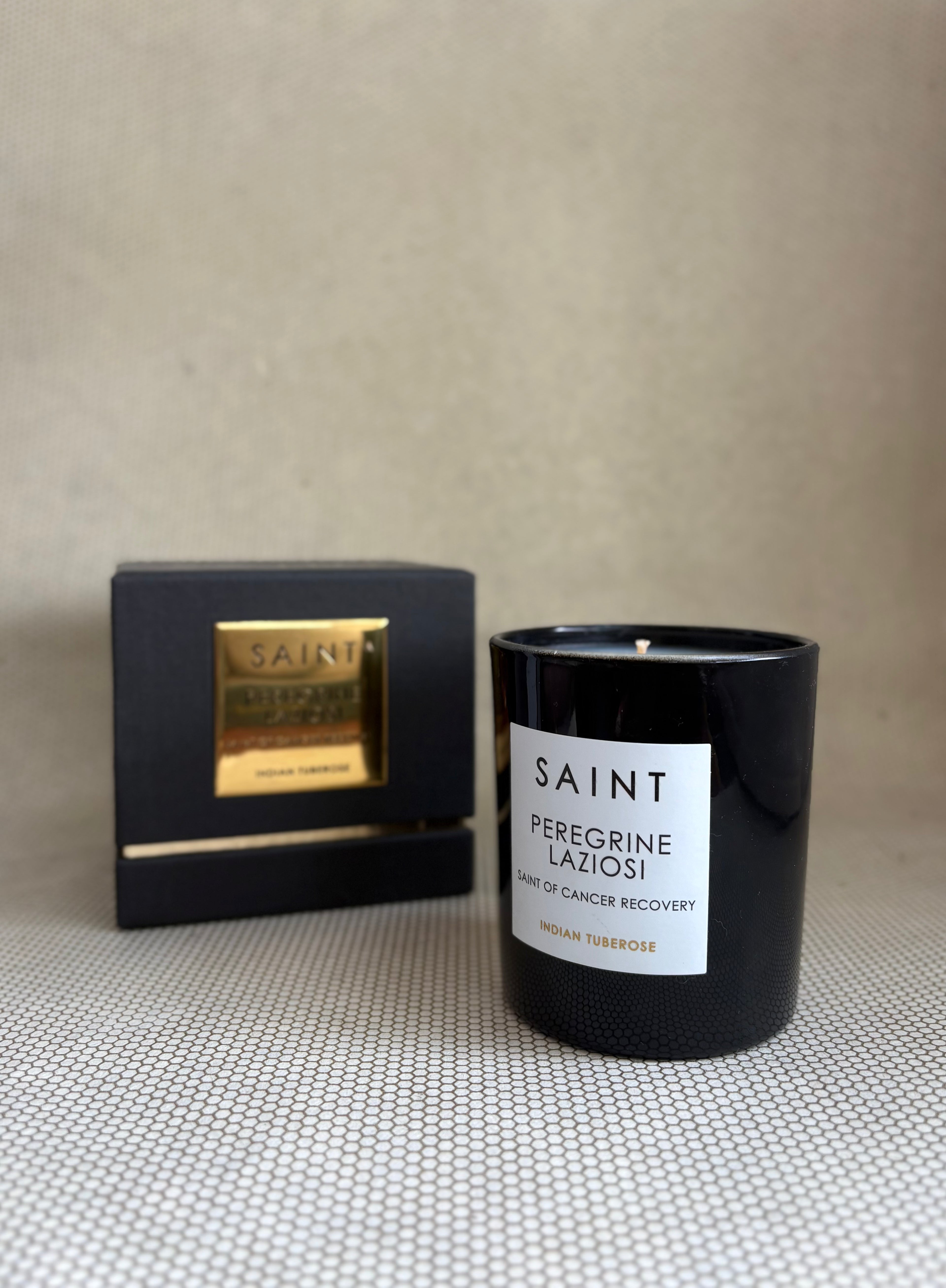 SAINT black glass candle with gold lid. black and gold box for candle. saint peregrine laziosi indian tubarose. 11 oz. (8 oz. pour), Measures 3.5" H x 3" D. 