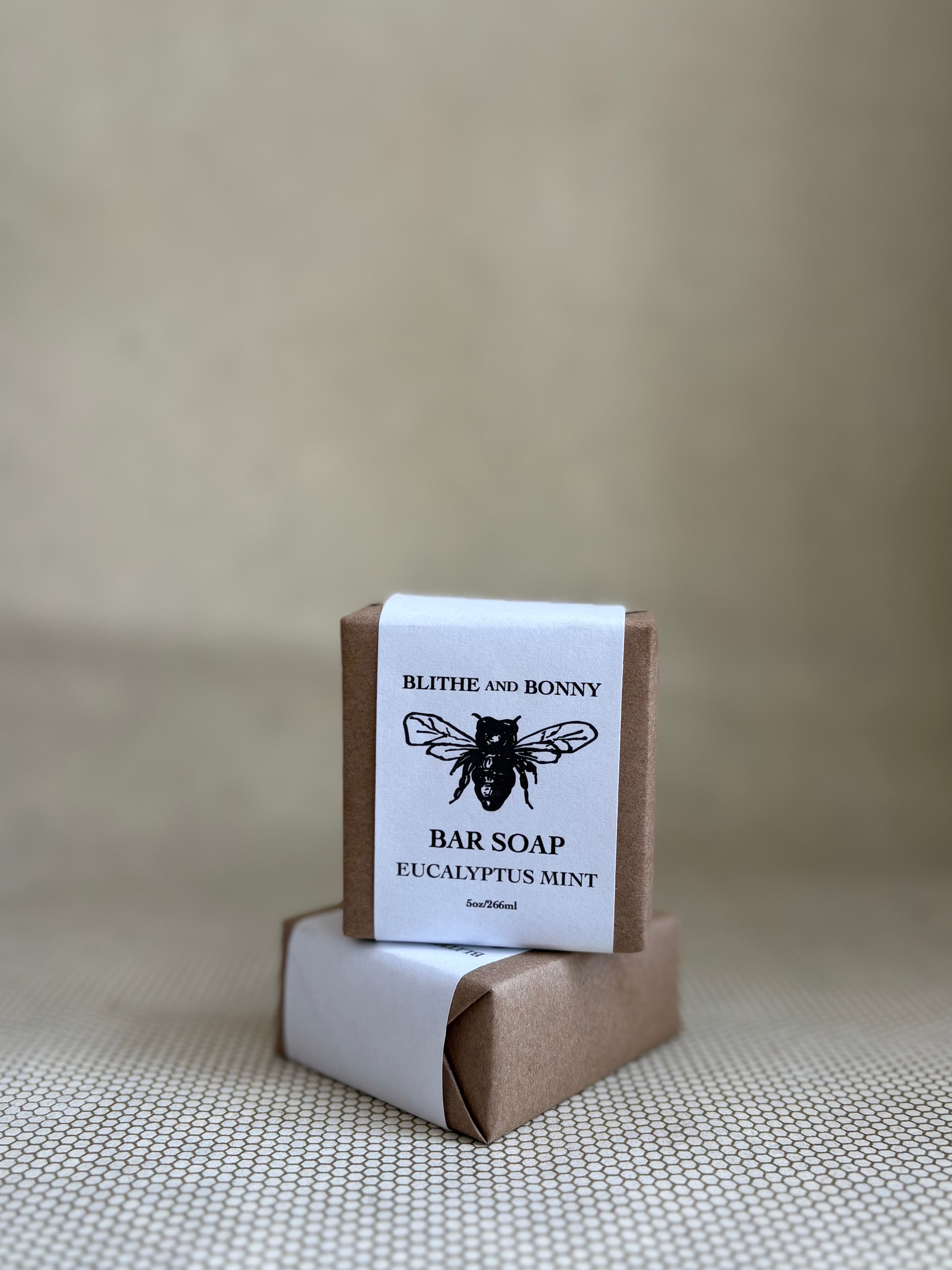 Bar of soap with a brown and white paper label cigar wrap. bumblebee graphic. vegan soap blithe and bonny. 