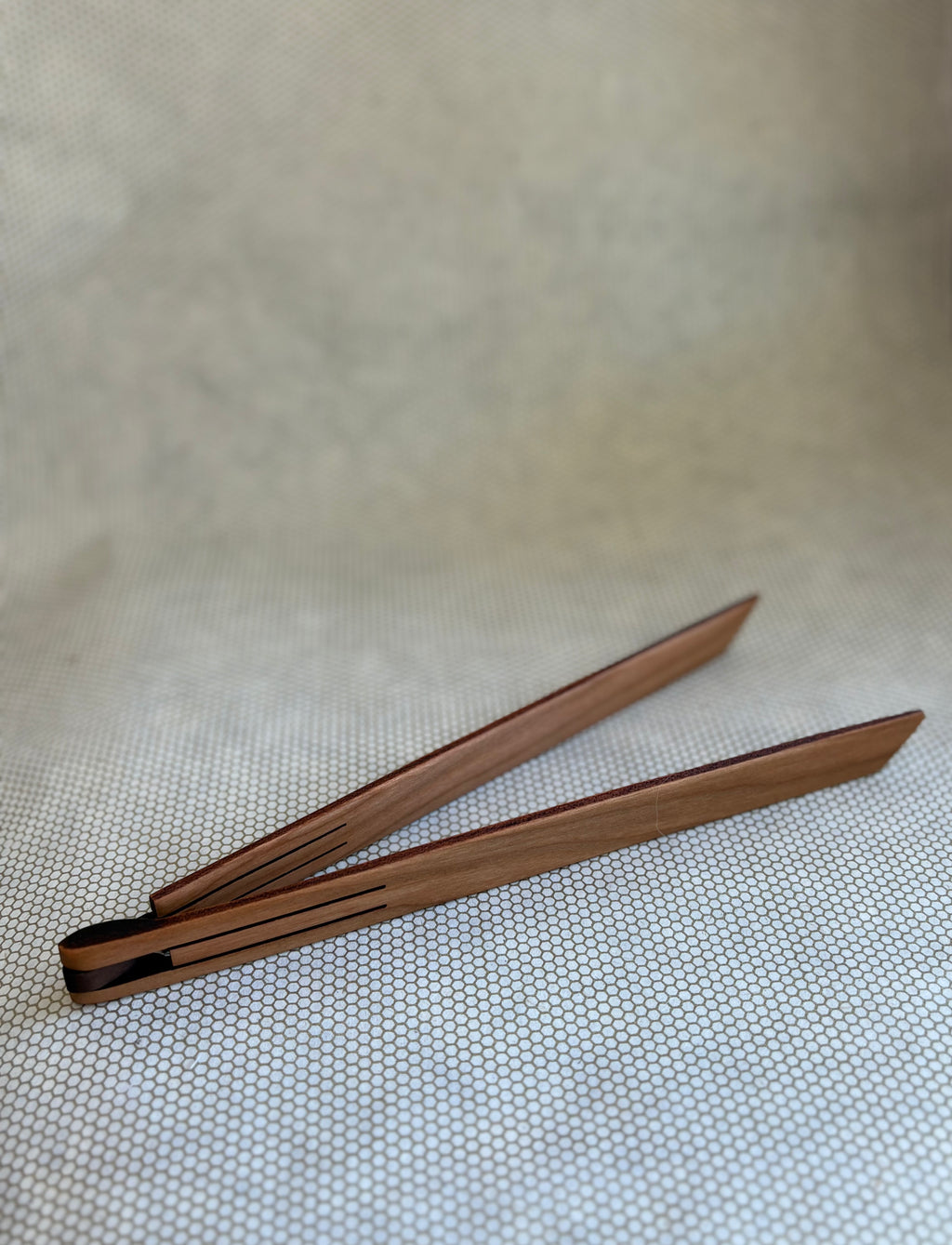 wooden inside out tongs for cooking on light neutral background. Jonathan's Spoons. 