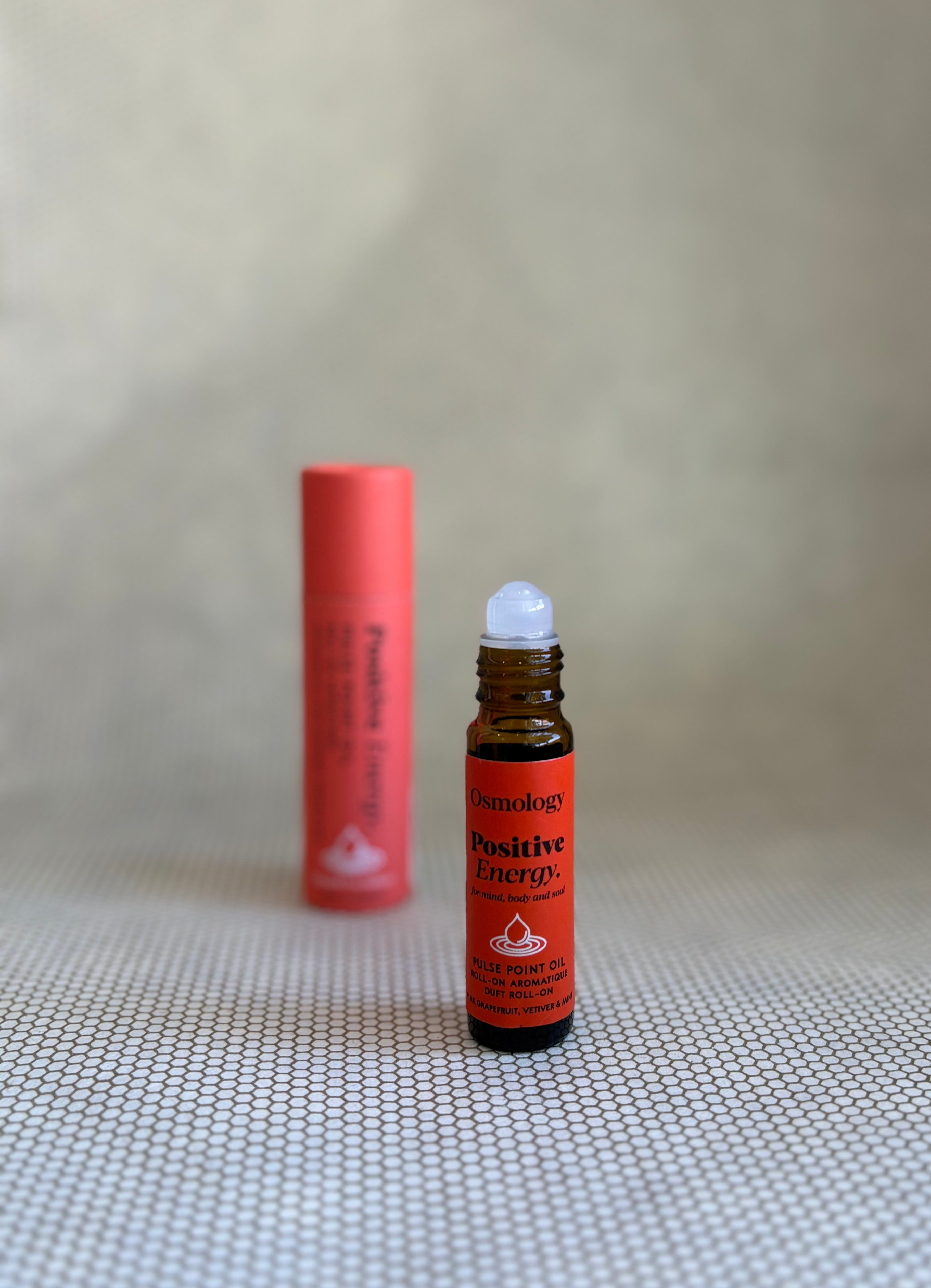 Osmology Positive Energy pulse point roll-on aromatherapy oil with red label and brown glass bottle. red tube packaging. 
