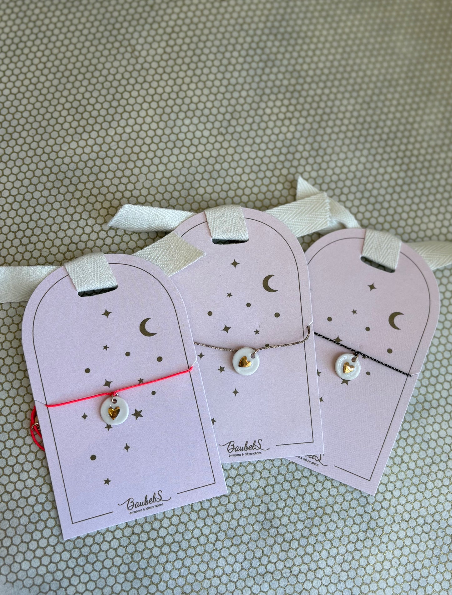 pink cardboard packaging and string charm bracelets with heart. 