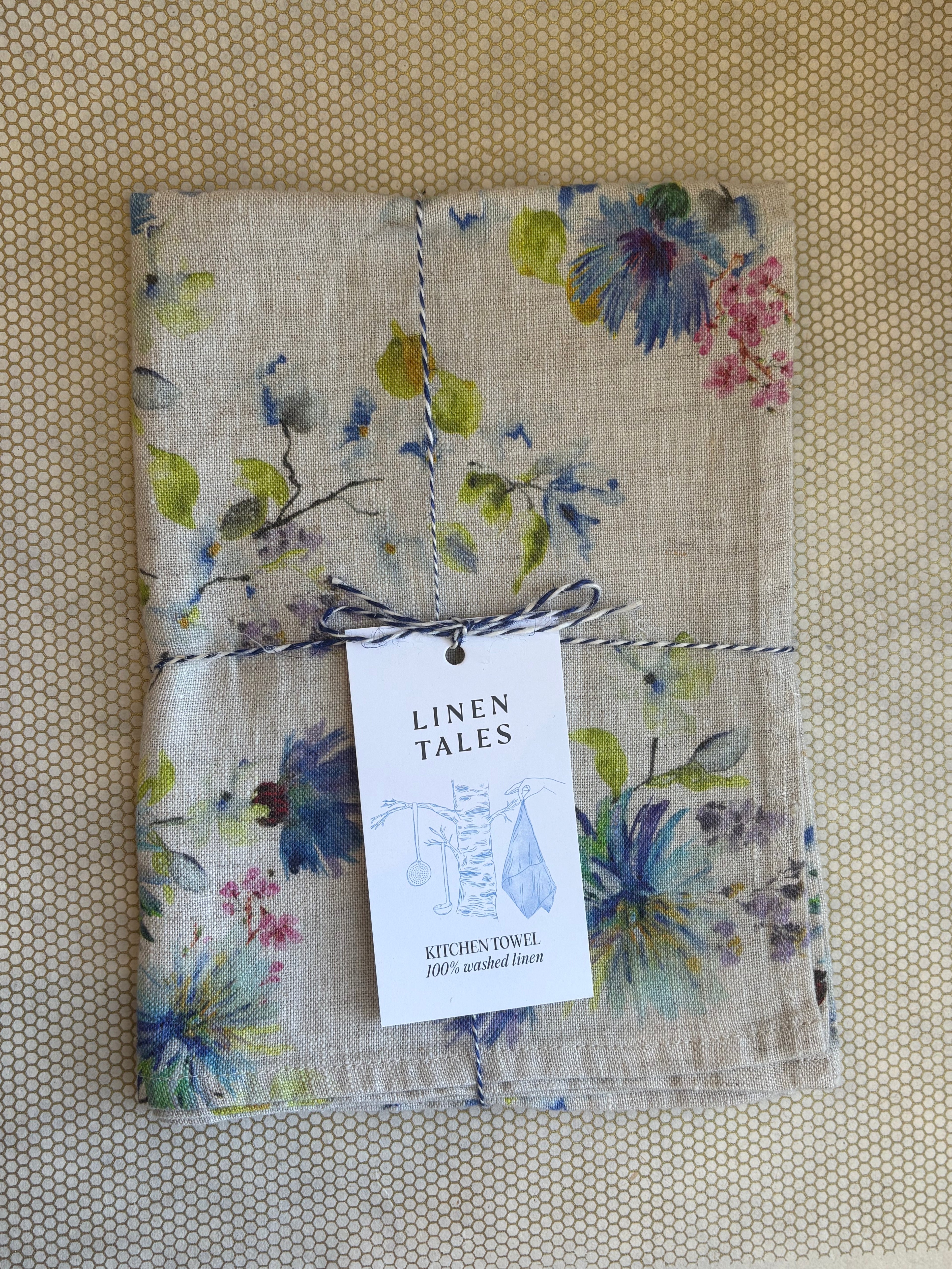 stacked kitchen towels. green, pink, blue, purple floral print on light natural linen background. Linen Tales 100% linen 18''x26''