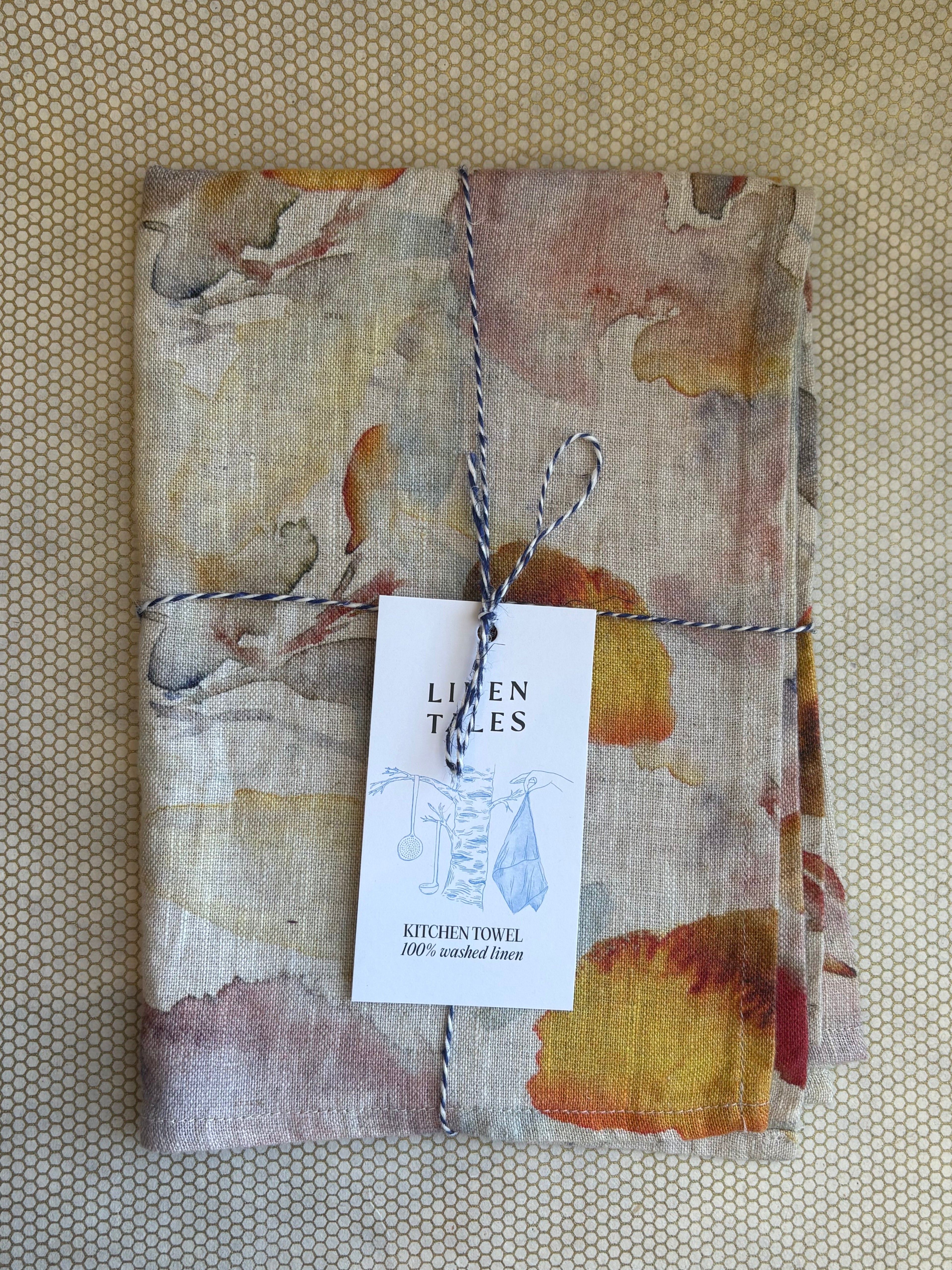 stacked kitchen towels. orange, red, blue, yellow, purple citrus print on natural linen background. Linen Tales 100% linen 18''x26''