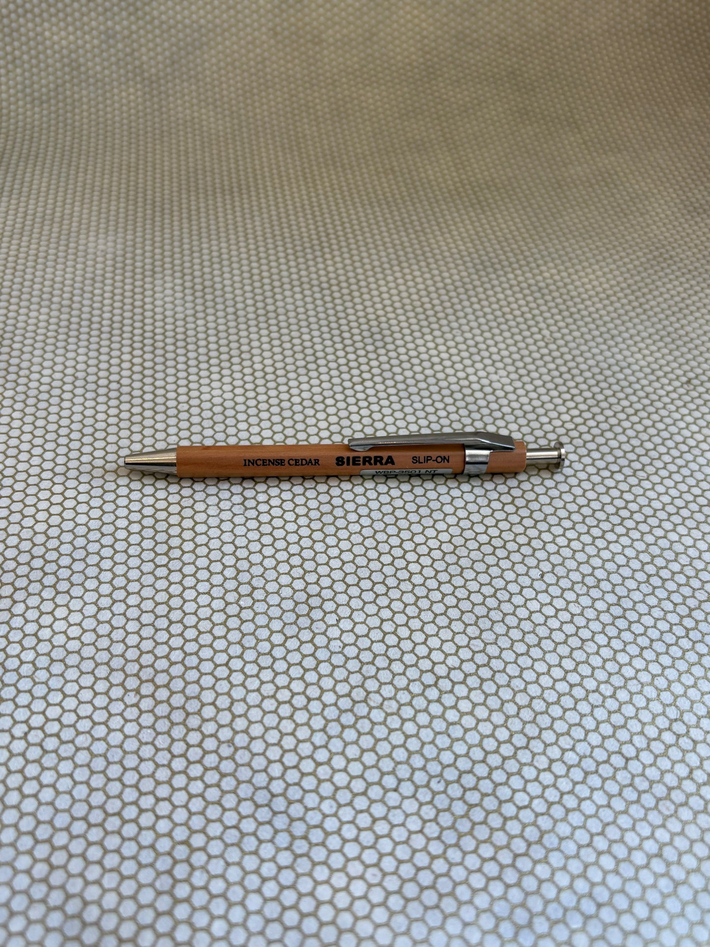 wooden ballpoint pen with Sierra branding on a textured beige background