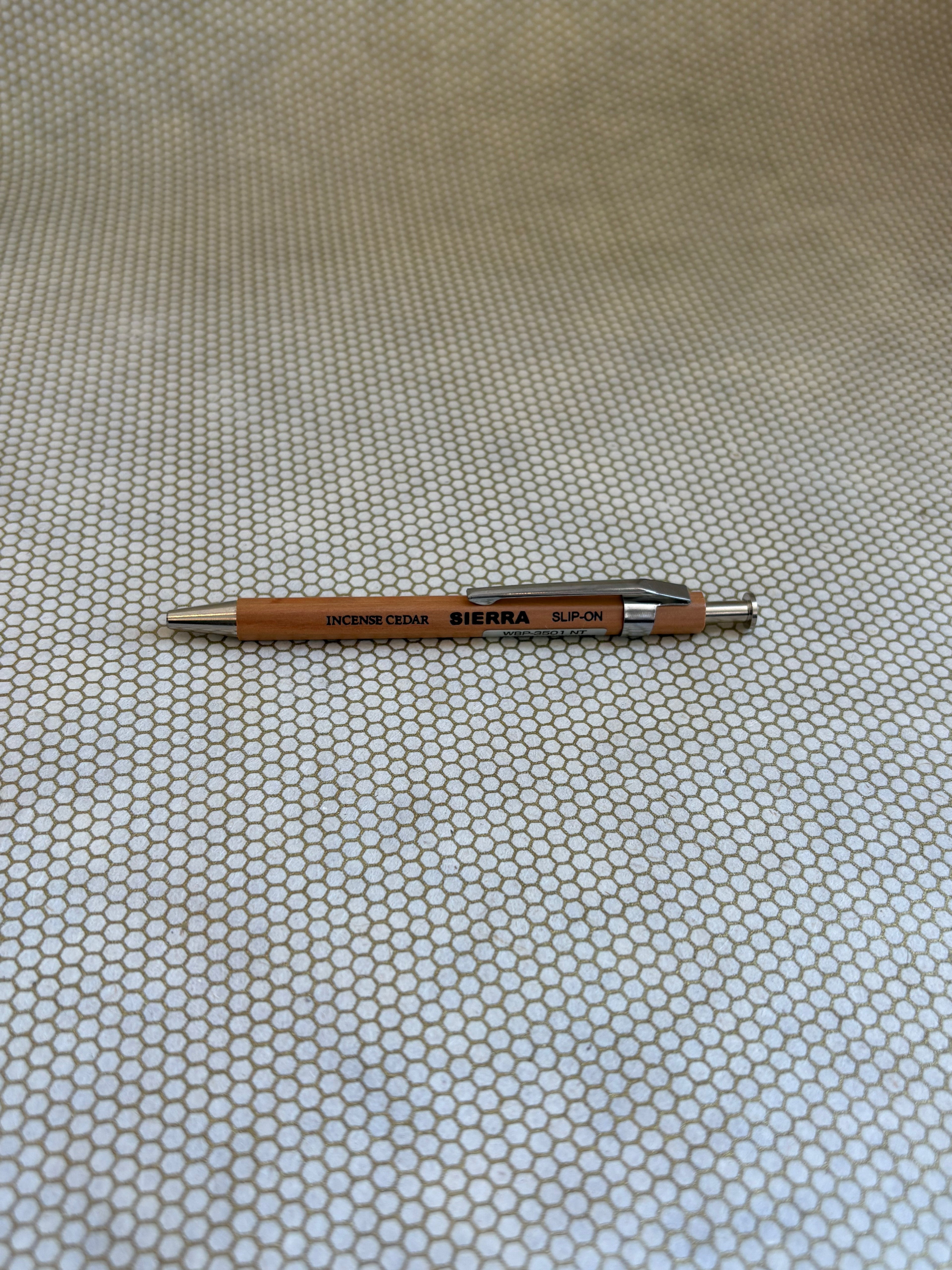 wooden ballpoint pen with Sierra branding on a textured beige background