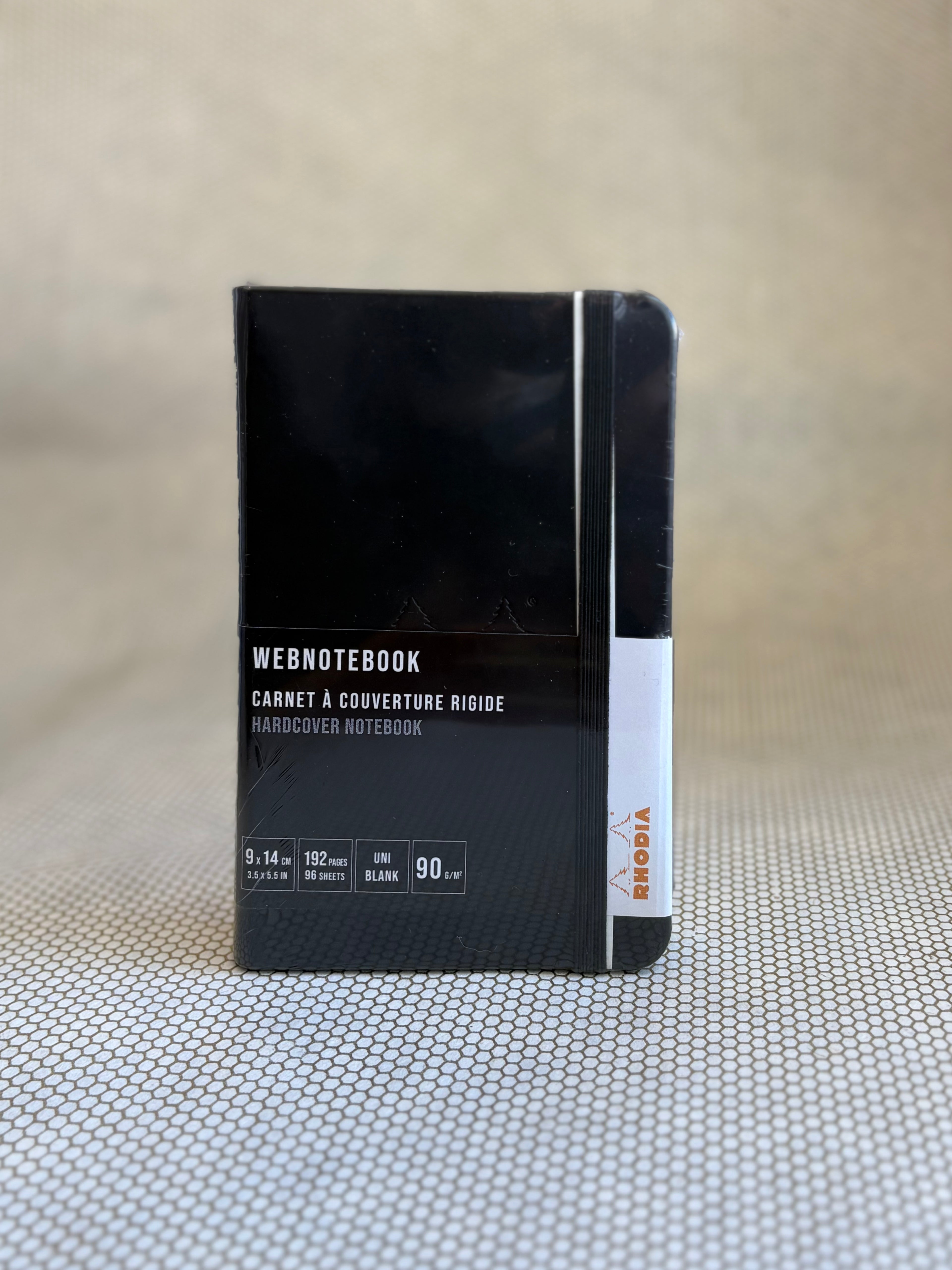 Black notebook with white text on a textured surface