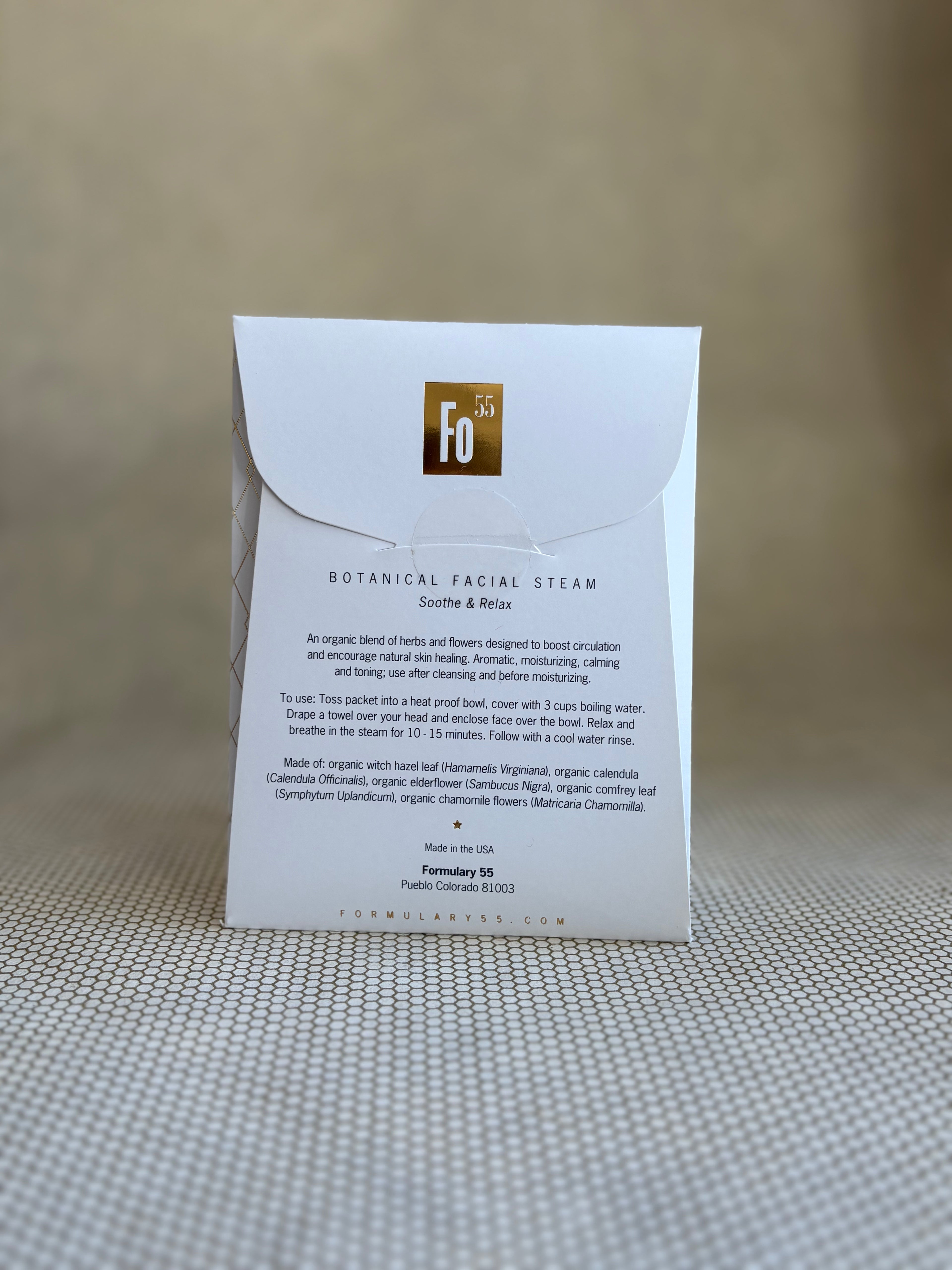 back of Formulary 55 botanical facial steam packaging on a textured surface with a neutral background