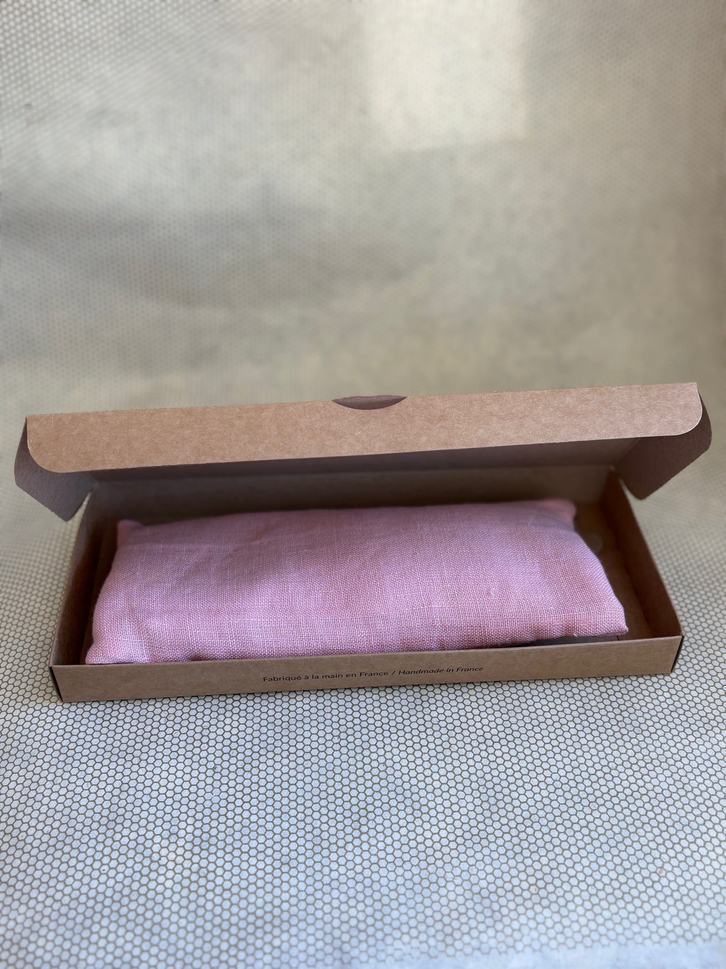 pink eye pillow in a brown cardboard box 
