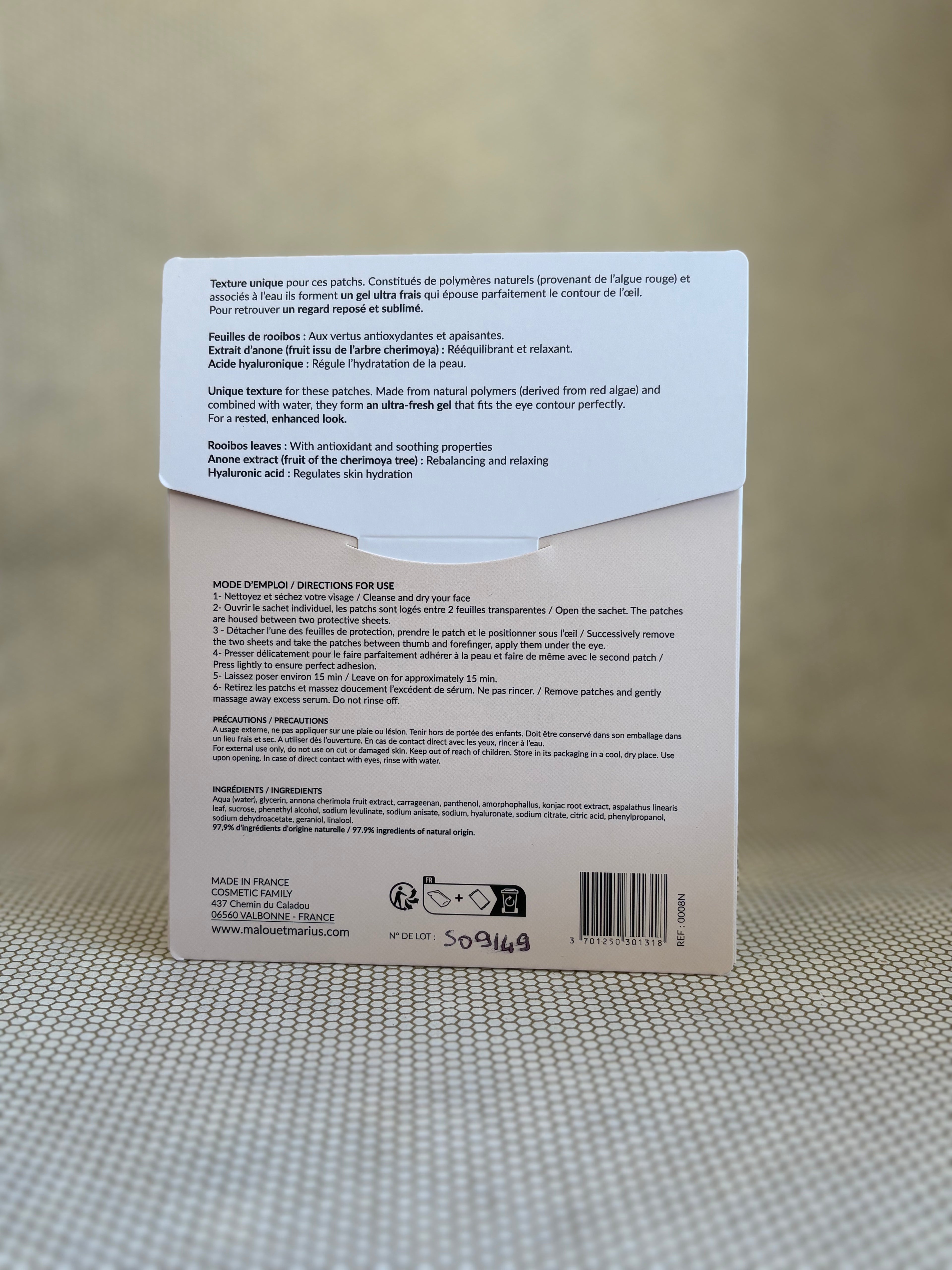 peach and white back of packaging of Malou & Marius eye patches on a textured surface