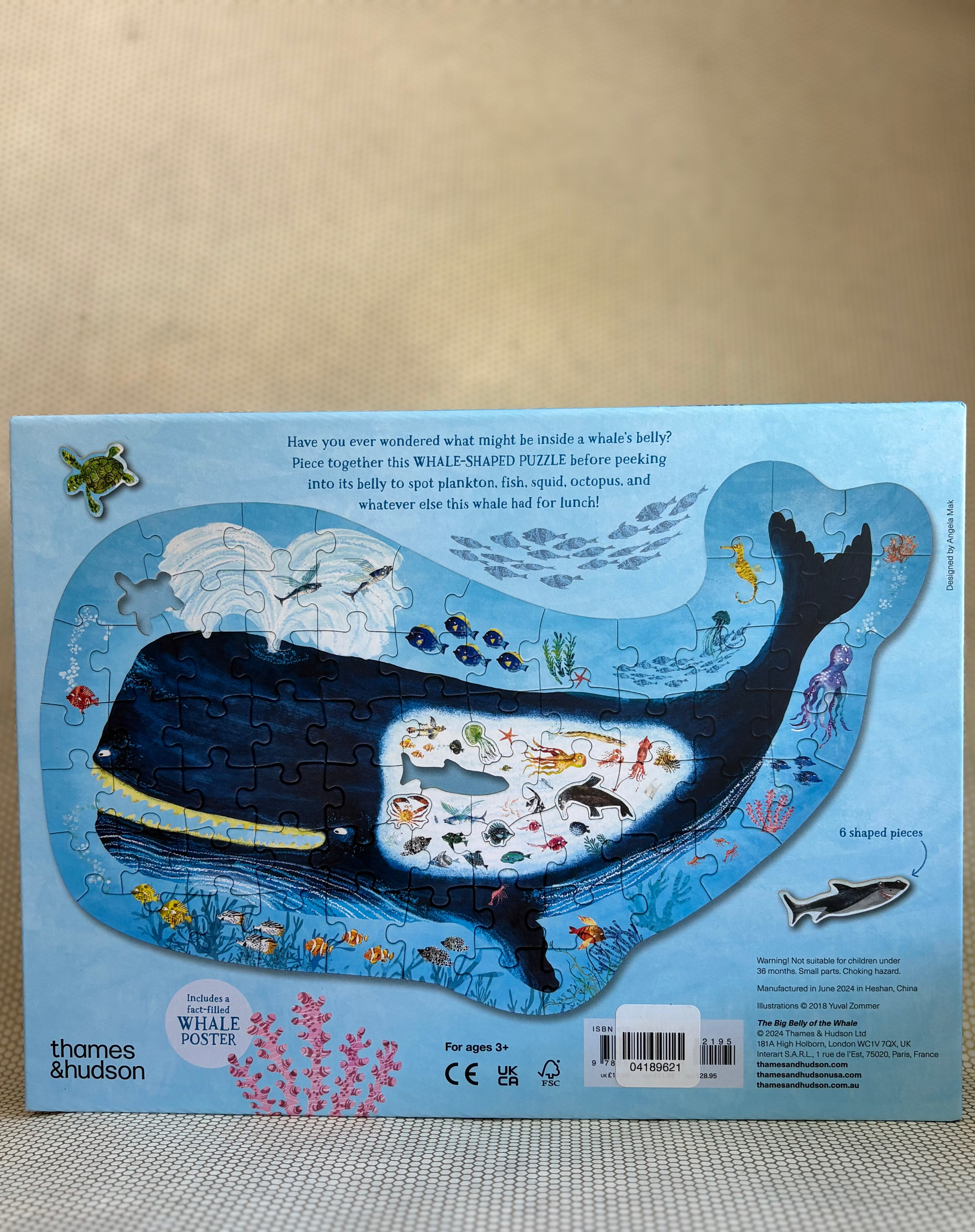 Whale-shaped puzzle with illustrations on a beige background