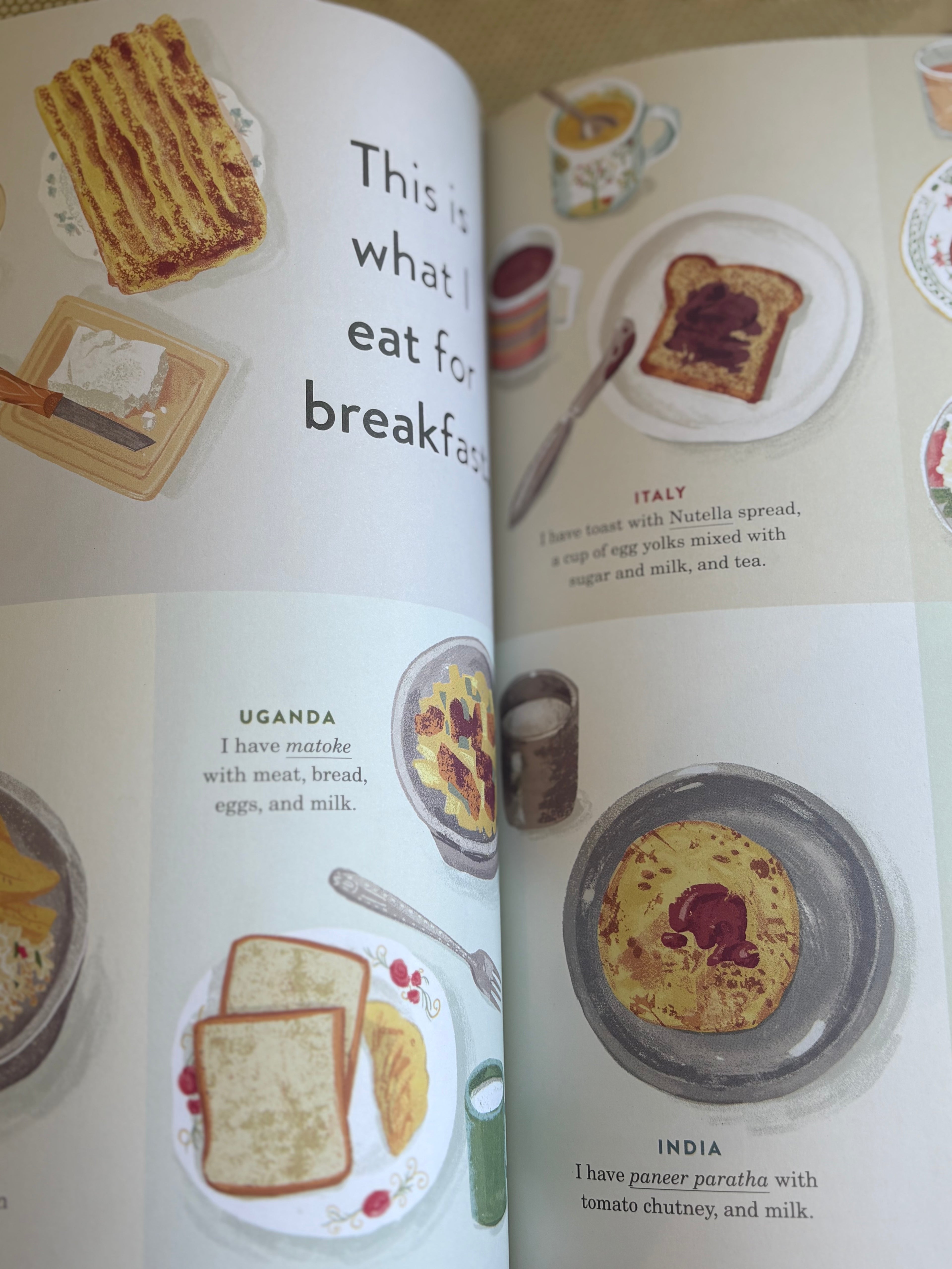 Open book showing illustrations of breakfast foods from different countries