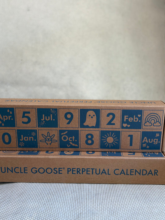 Uncle Goose perpetual calendar with blue text and symbols on a cardboard box.
