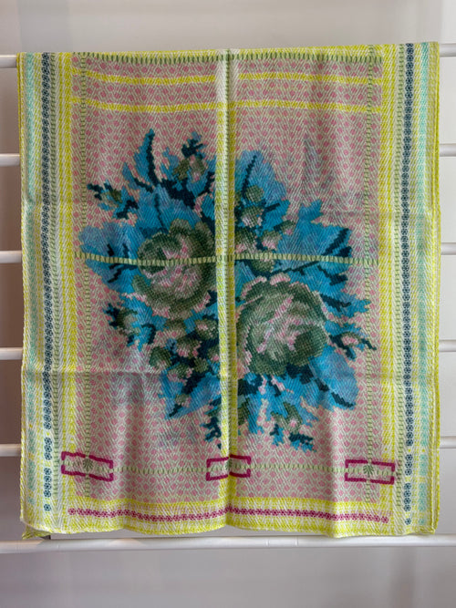floral brightly colored scarf on rack pink, blue, green, yellow design. 