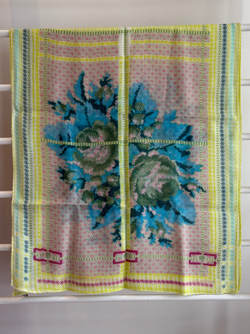 floral brightly colored scarf on rack pink, blue, green, yellow design. 