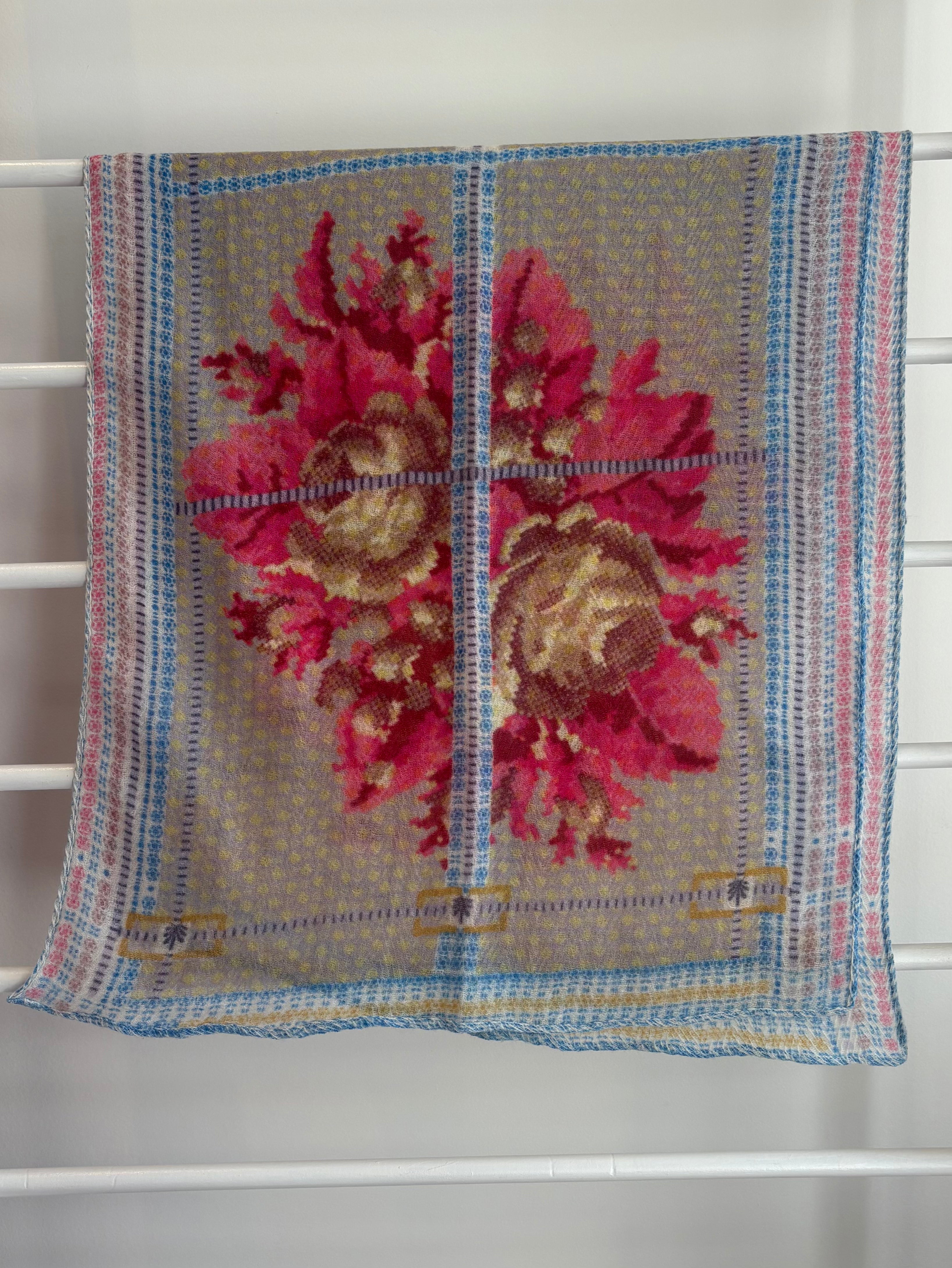 floral brightly colored scarf on rack pink, blue, red, yellow brown design. 