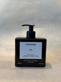 front of liquid soap bottle in Fig scent by Osmology. glass bottle hand soap on neutral background. 