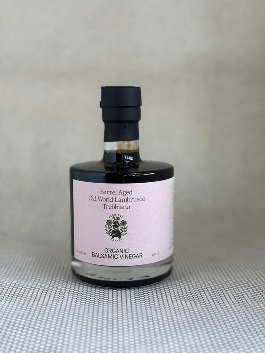 Bottle of Flamingo Estate organic balsamic vinegar on a textured surface with a neutral background