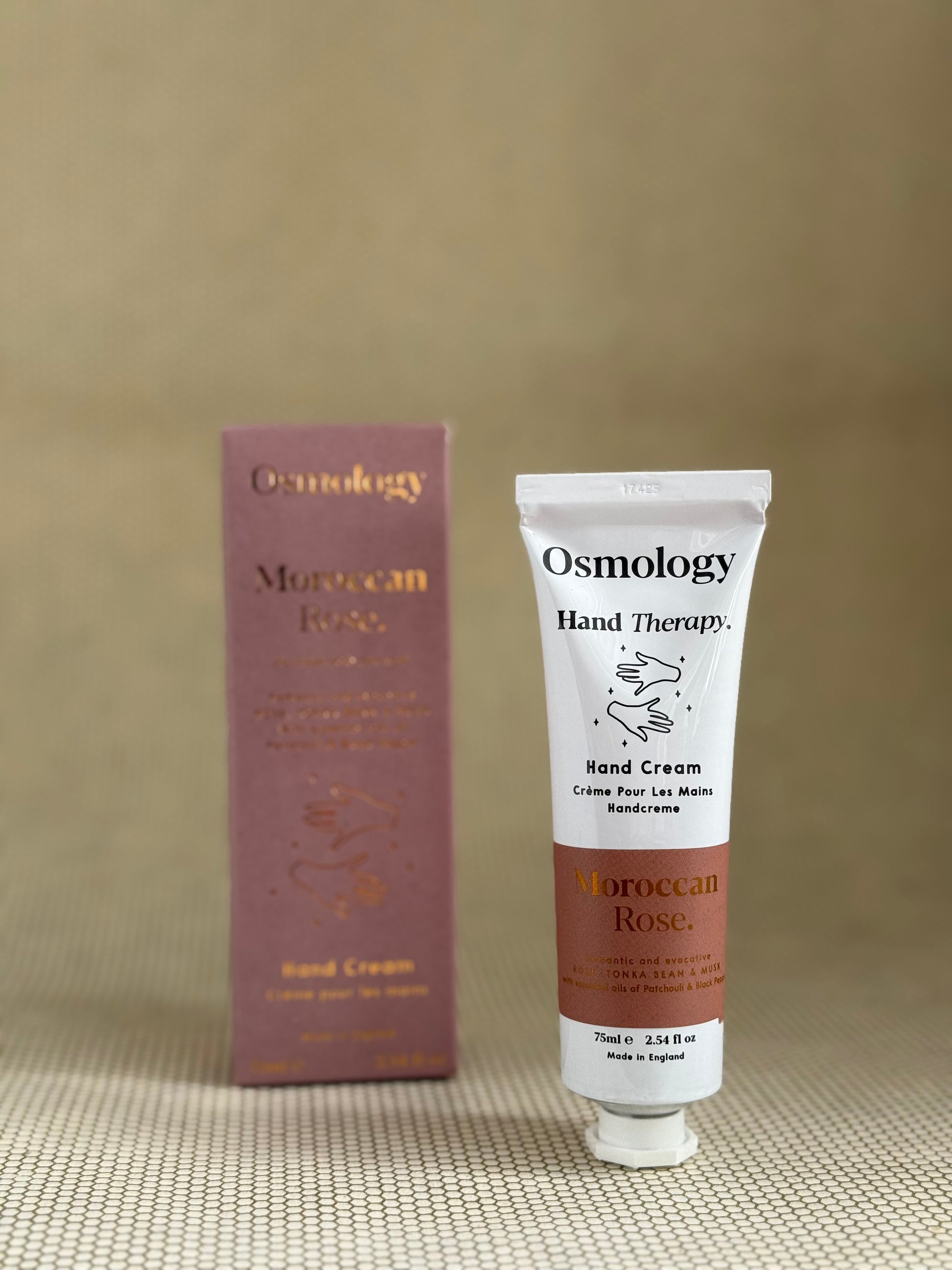 Osmology Moroccan Rose hand cream tube and packaging on a beige background