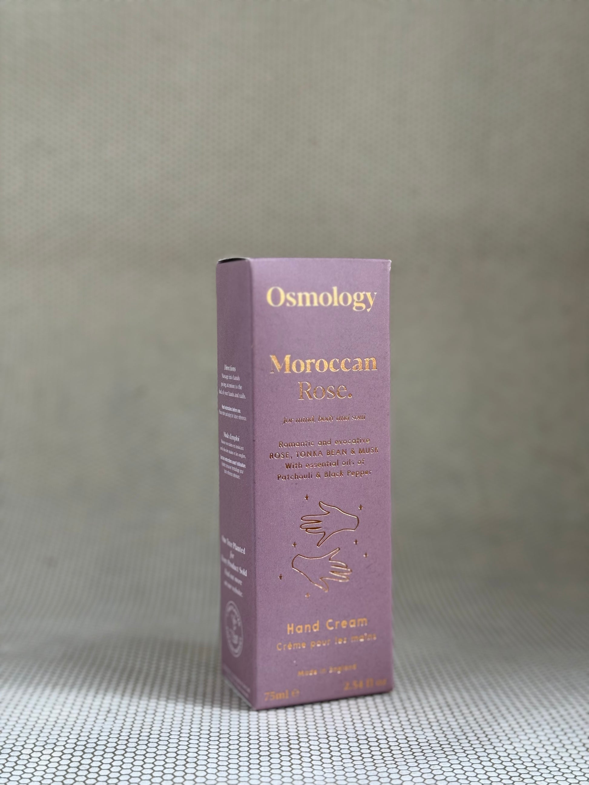 Osmology Moroccan Rose hand cream box on a textured gray surface