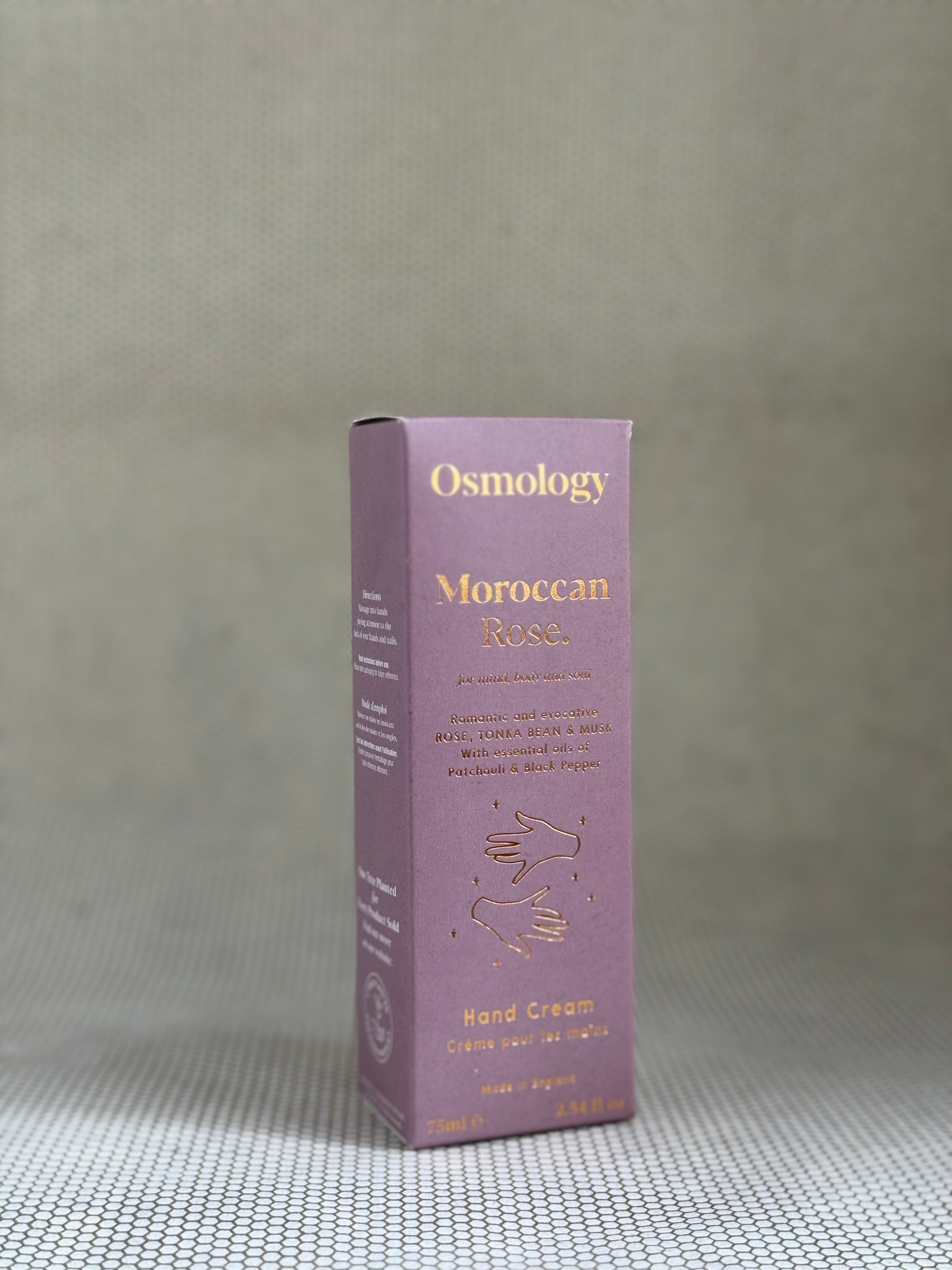 Osmology Moroccan Rose hand cream box on a textured gray surface