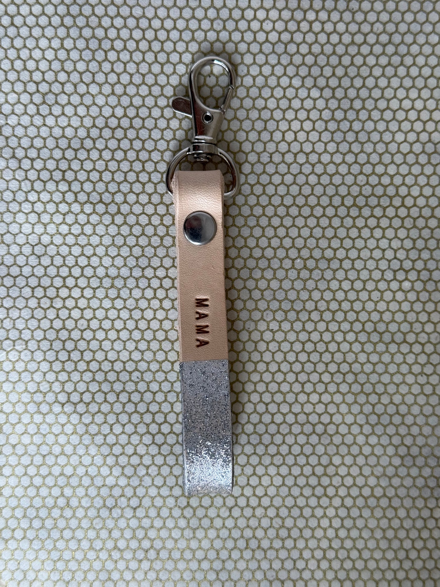 silver color keychains with leather straps and "mama" lettering on leather. 
