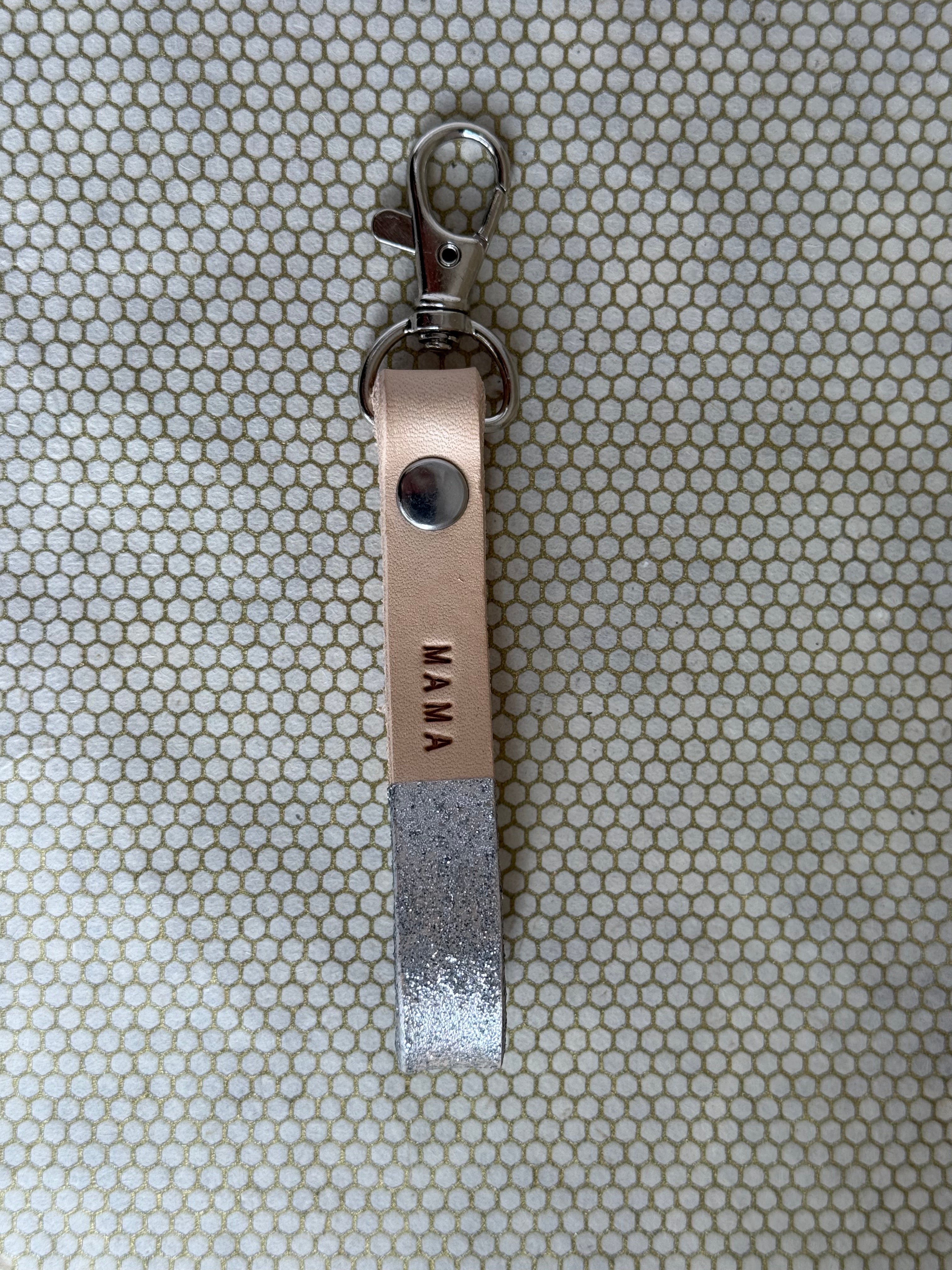silver color keychains with leather straps and "mama" lettering on leather. 