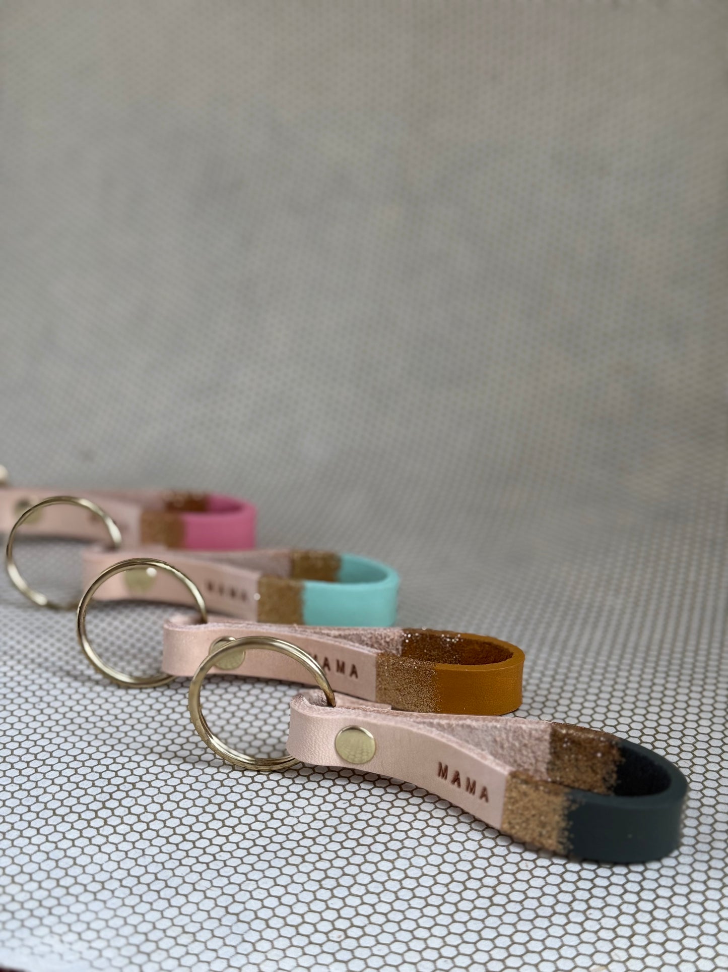Set of varying color keychains with leather straps and "mama" lettering on leather. 