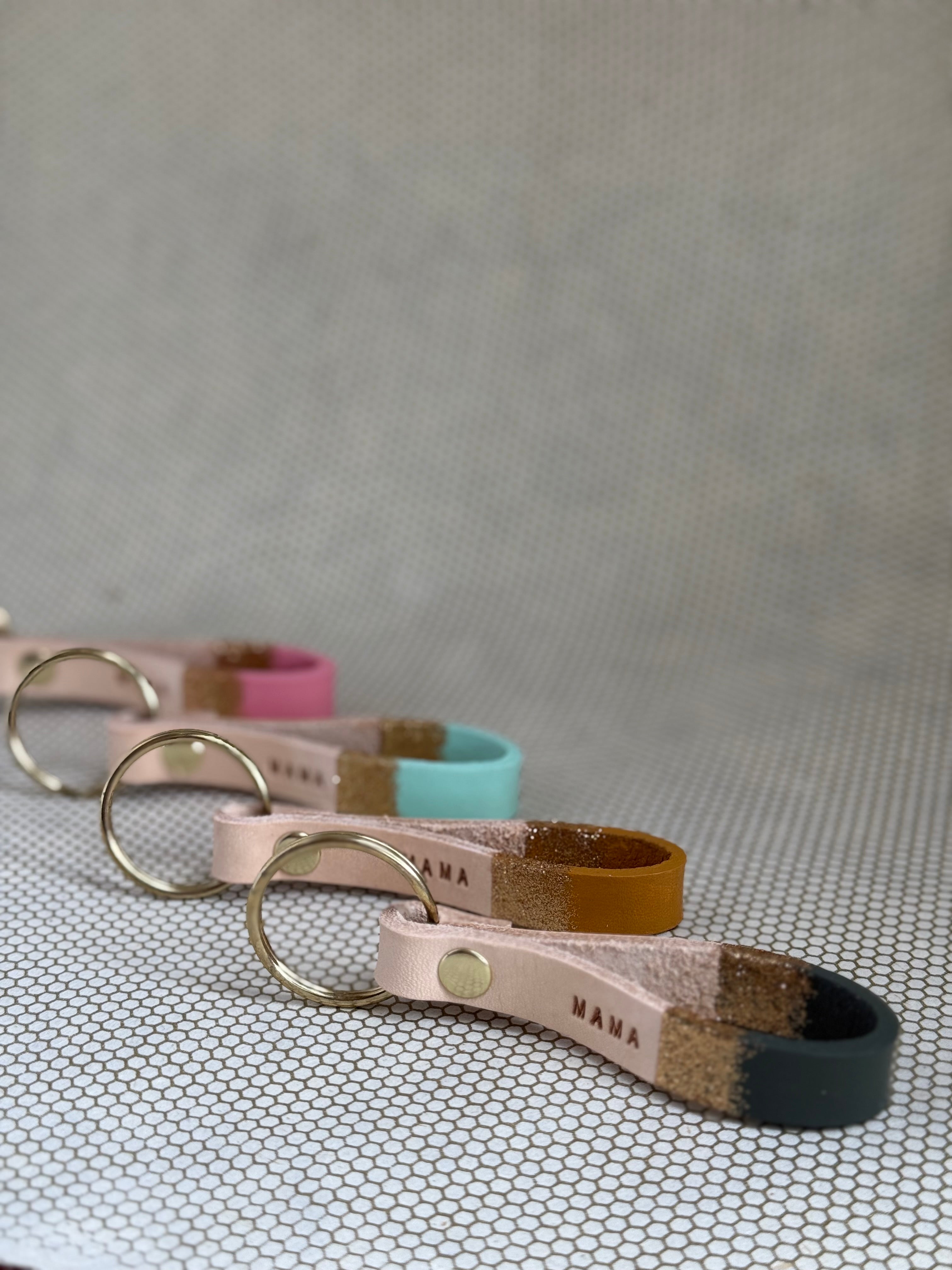 Set of varying color keychains with leather straps and "mama" lettering on leather. 