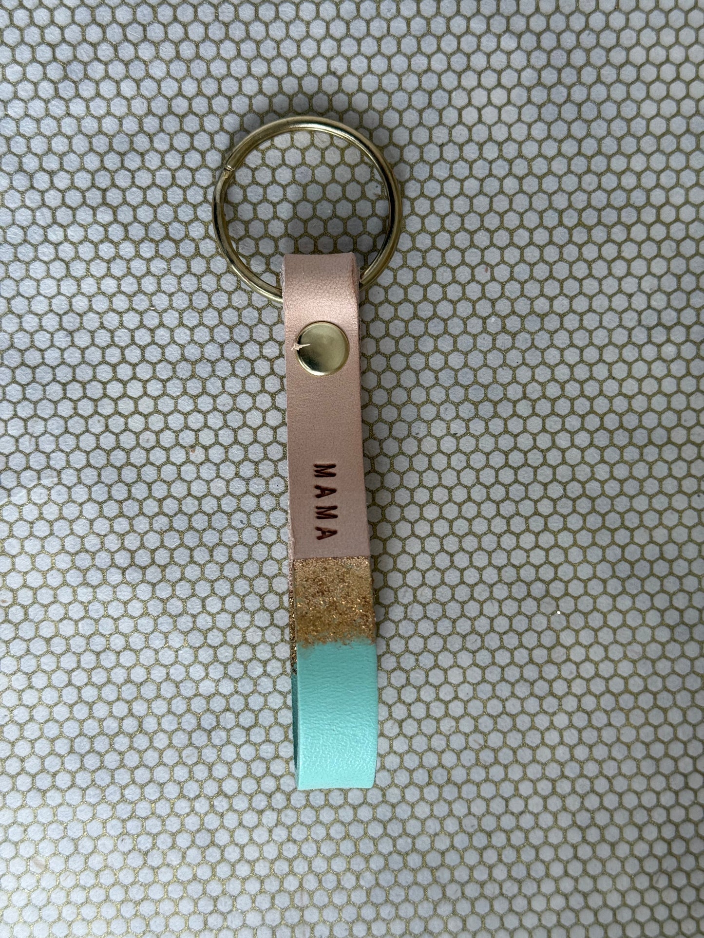 MAMA Keychain with leather tag and turquoise accent on a patterned background