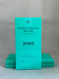 turquoise dark chocolate bar packaging with jcoco branding on neutral background. 