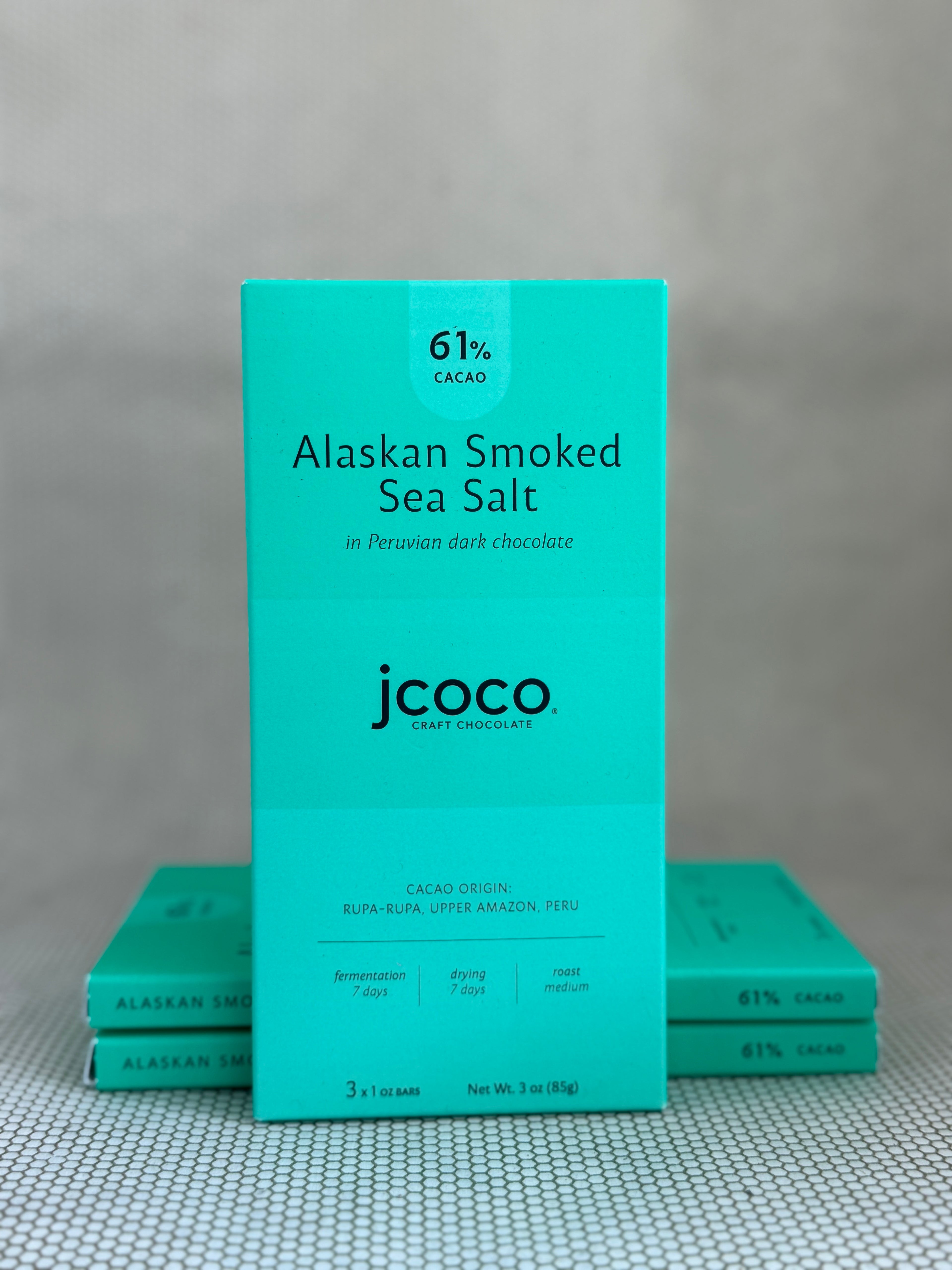 turquoise dark chocolate bar packaging with jcoco branding on neutral background. 