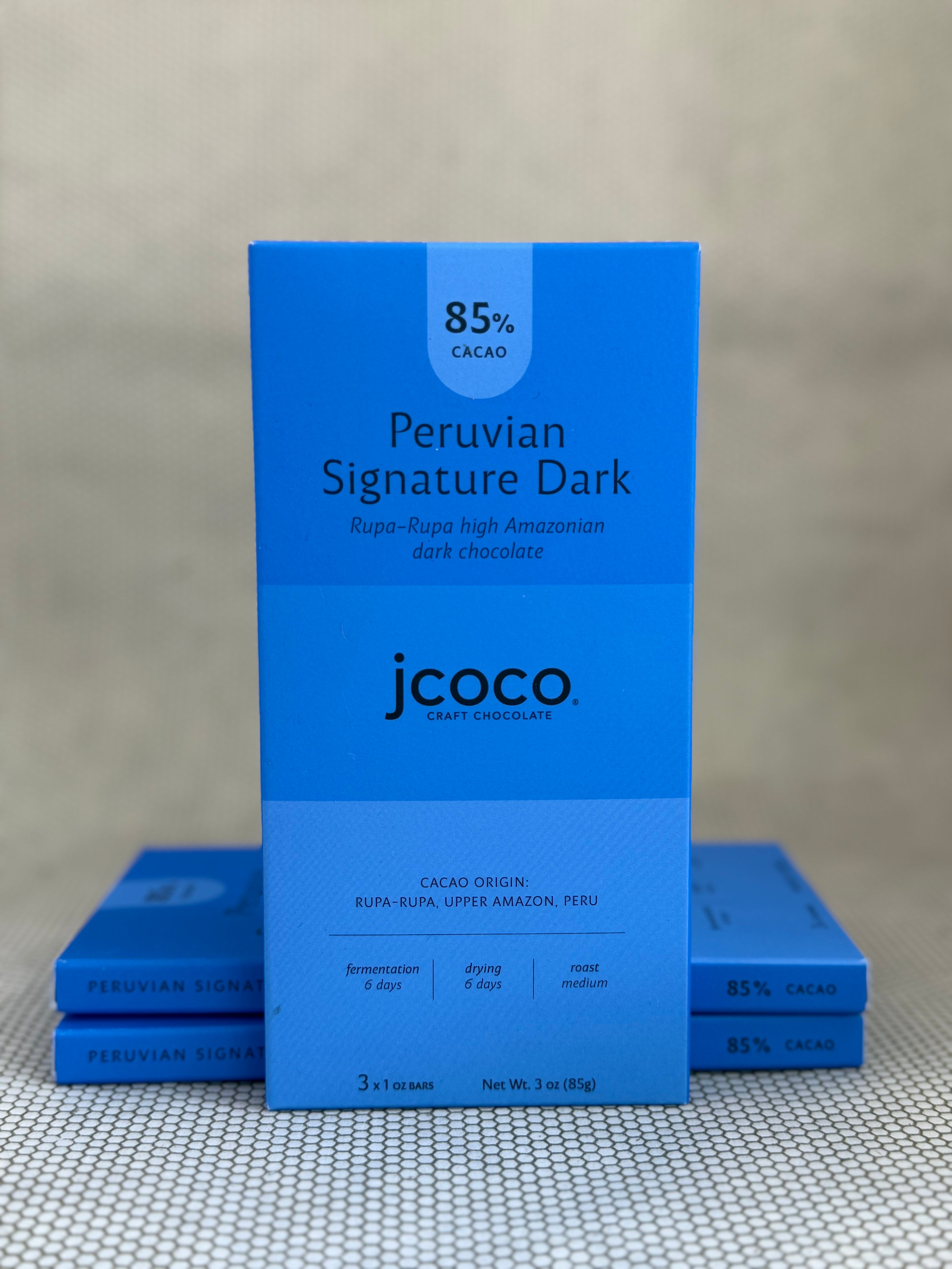 blue dark chocolate bar packaging with jcoco branding on neutral background. 