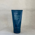 Tube if Ursa Major stellar shave cream in dark blue packaging on neutral background. 