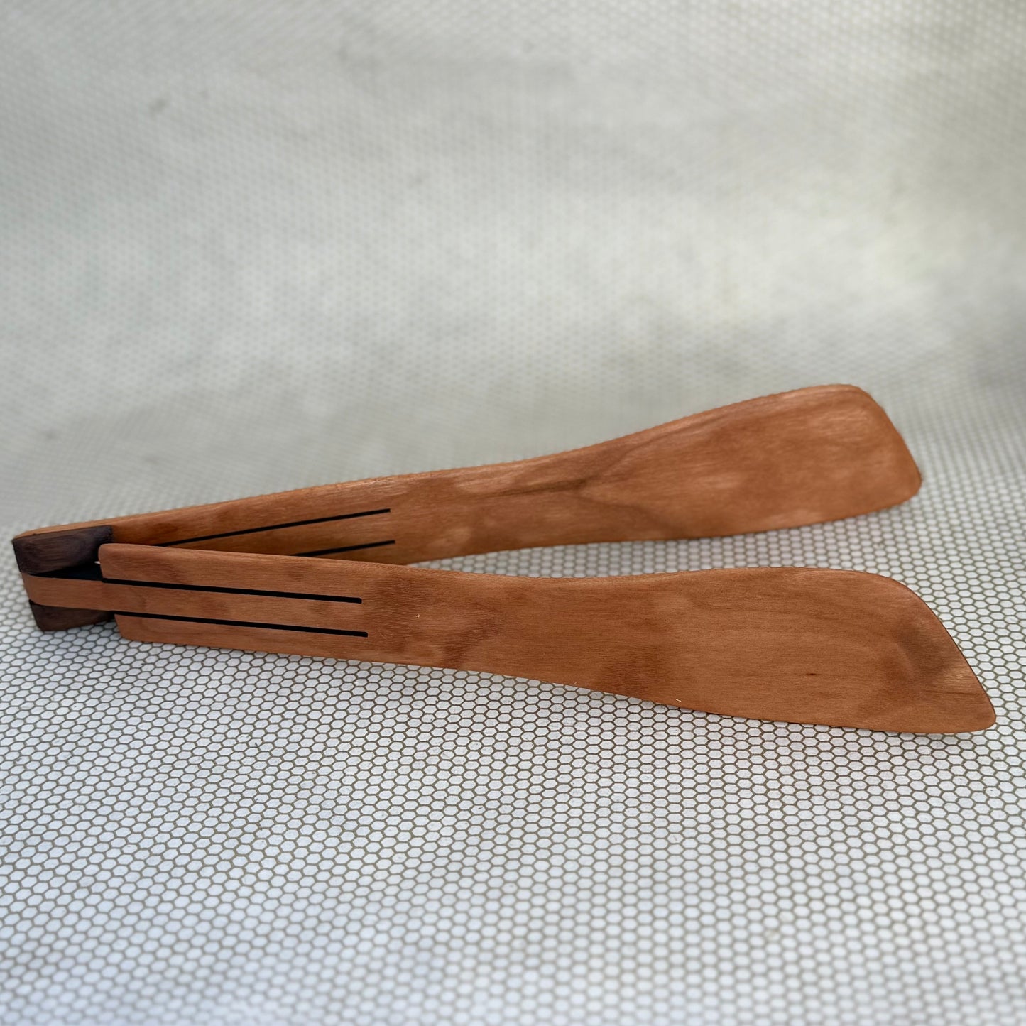 wooden inside out tongs on light neutral background. Jonathan's Spoons. 