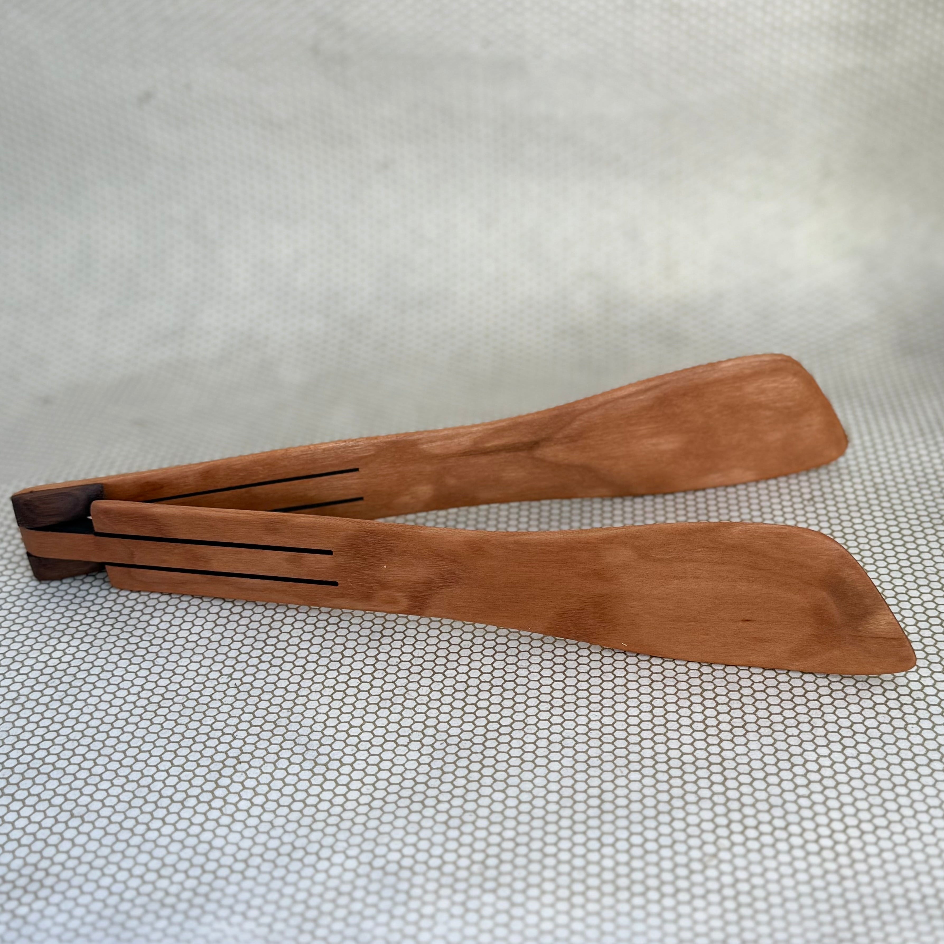 wooden inside out tongs on light neutral background. Jonathan's Spoons. 