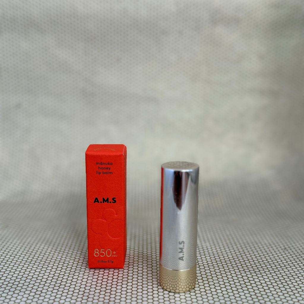 Activist manuka lip balm in silver lipstick applicator on neutral background with red box.