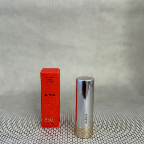 Activist manuka lip balm in silver lipstick applicator on neutral background with red box.