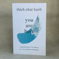 Book cover of 'You Are Here' by Thich Nhat Hanh on a textured surface.