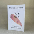 Book titled 'True Love' by Thich Nhat Hanh on a textured surface with a neutral background